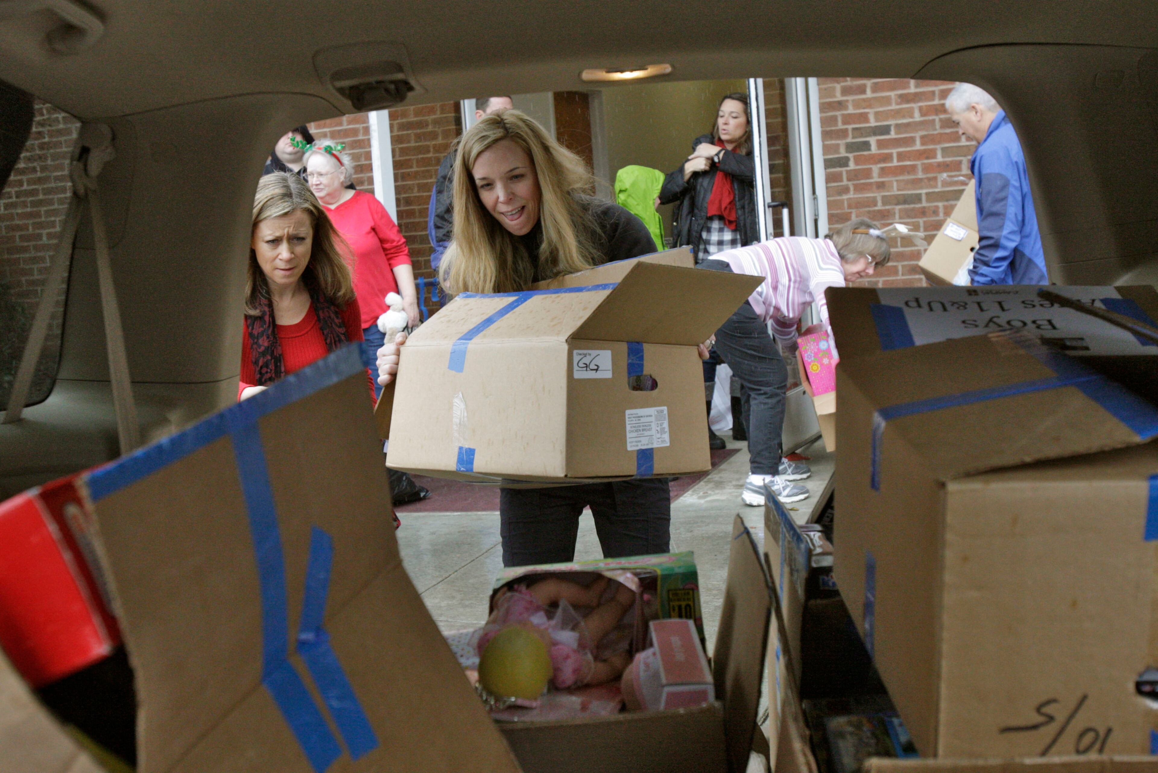 Courtney Roberts loads one of the vehicles in the Christmas caravan at the Campus Church of Christ in Norcross Dec. 24, 2012.