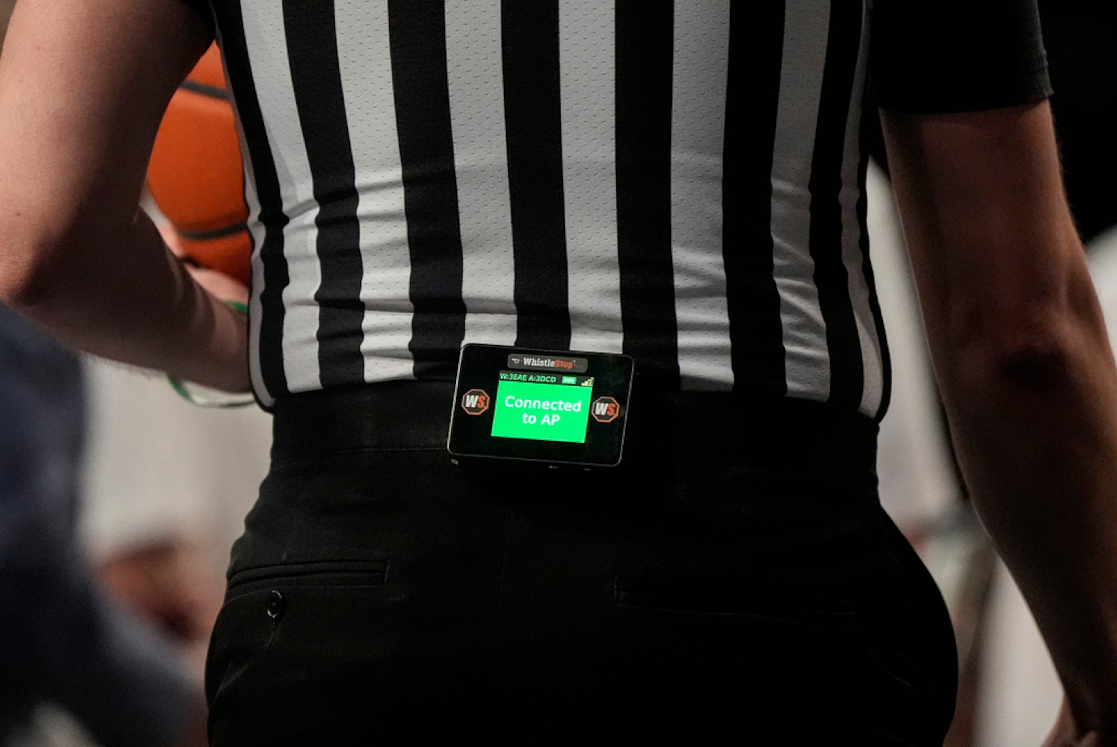 An official wears a PTS, or Precision Time System digital device during the first half of an NCAA basketball game between Georgia Tech and Louisville, Saturday, Feb. 1, 2025, in Atlanta. (AP Photo/Mike Stewart)