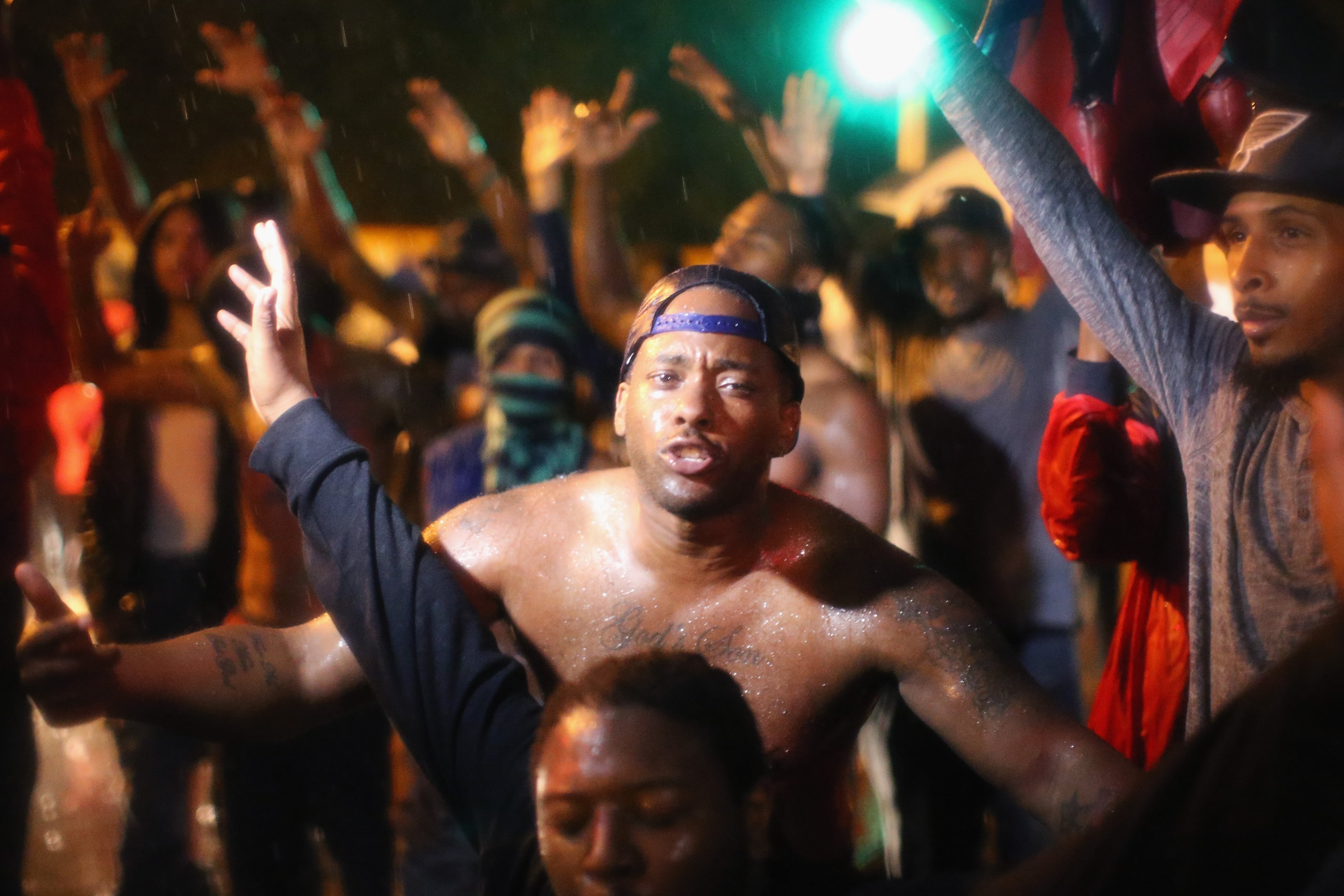 FERGUSON, MO - AUGUST 17: People wait for reaction from police after they refused to honor the midnight curfew on August 17, 2014 in Ferguson, Missouri. The curfew was imposed on Saturday in an attempt to reign in the violence that has erupted nearly every night in the suburban St. Louis town since the shooting death of teenager Michael Brown by a Ferguson police officer on August 9. (Photo by Scott Olson/Getty Images)