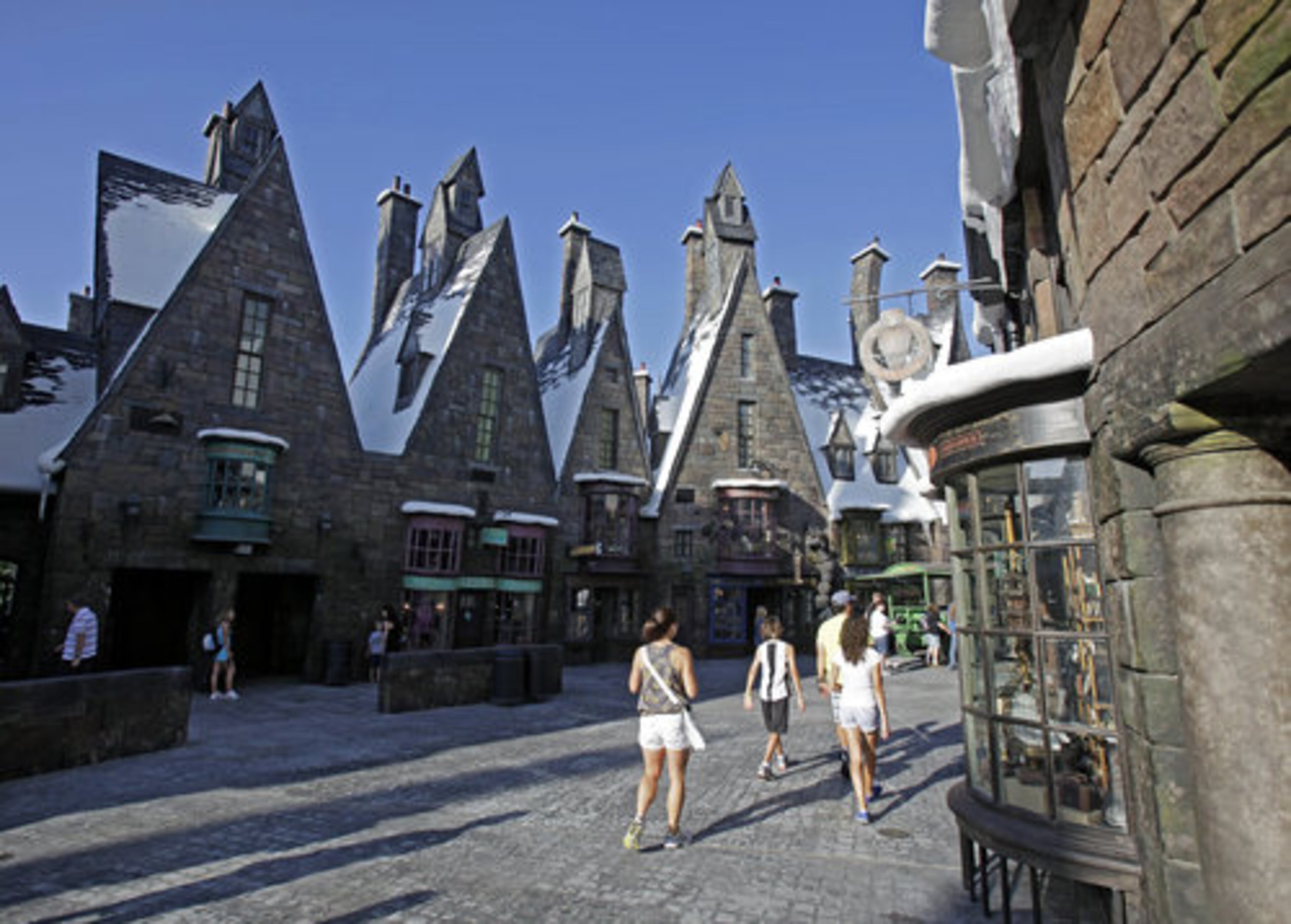 Visitors stroll the streets of Hogsmeade in The Wizarding World of Harry Potter at Universal Orlando theme park in Orlando, Fla.