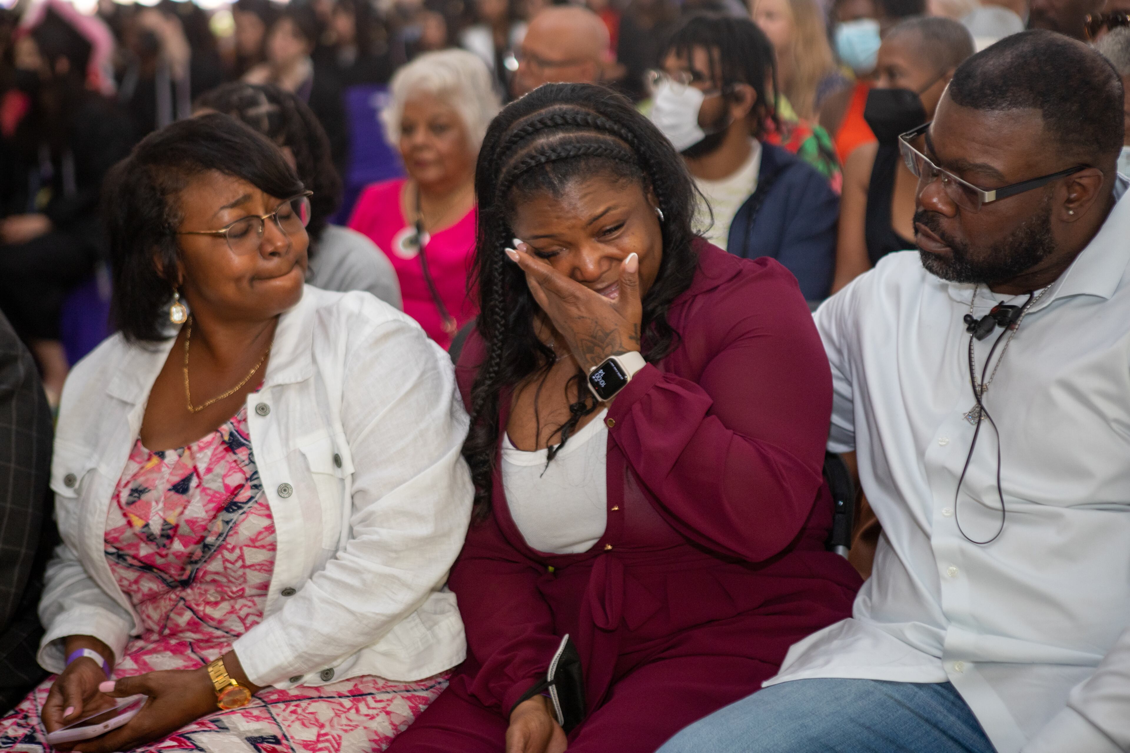 Monica Hayes gets emotional while her daughter, Ryan Hayes-Owens, addresses the 282 graduates during Agnes Scott College's graduation ceremony on Saturday, May 14, 2022. Monica is supported by Ryan’s grandmother Carmen Hayes, left, and Monica’s husband Melvin Holloway, right. (Jenni Girtman for The Atlanta Journal-Constitution)