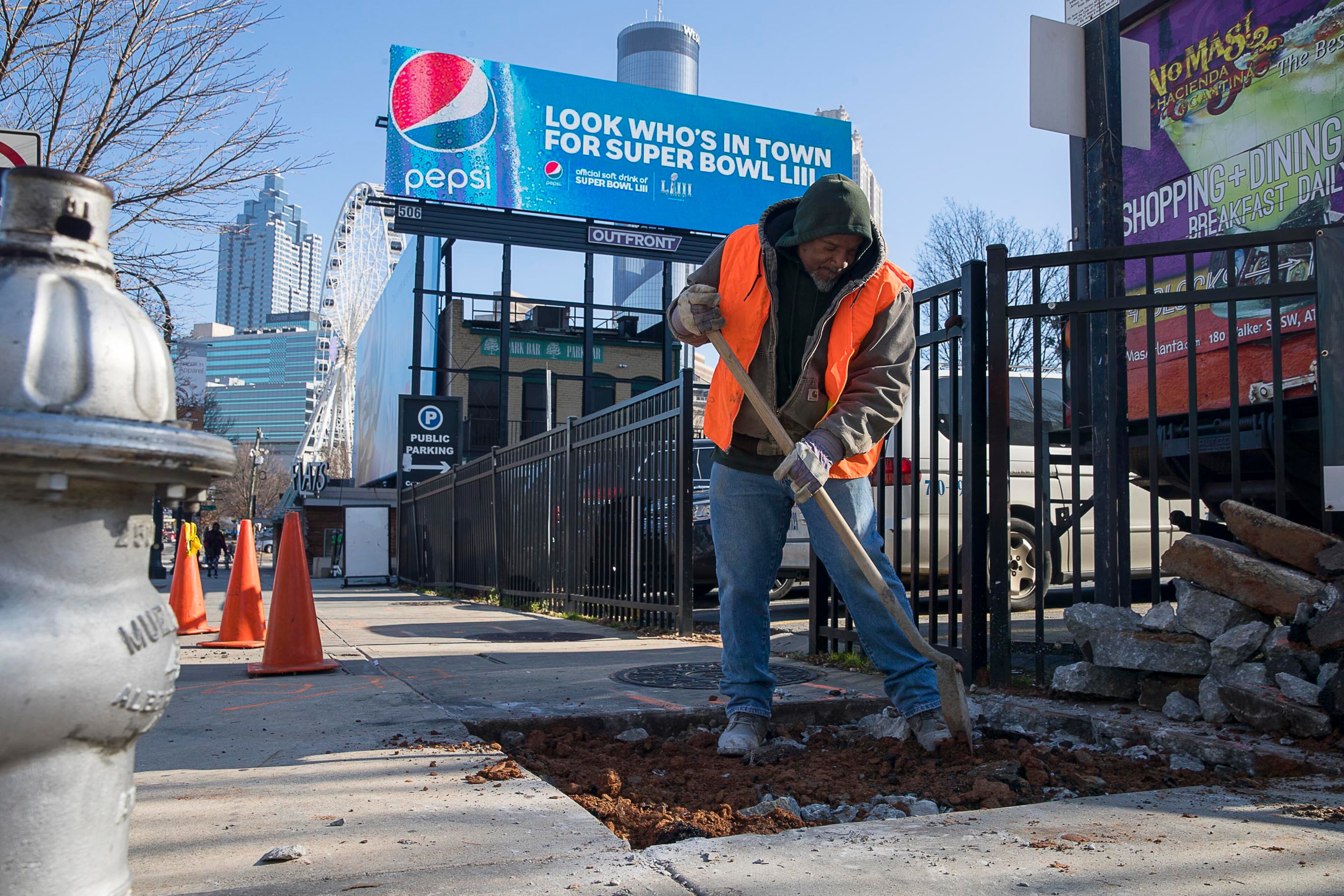 01/16/2019 -- Atlanta, Georgia -- Bobby Adams of Future Concrete Company LLC prepares a hole that will be filled with concrete at the intersection of Centennial Olympic Park Drive NW and Marietta Street NW in Atlanta, Wednesday, January 16, 2019. According to an Atlanta Sheriff's Officer, a company recently checked the underground fiber optics cables near Mercedes-Benz Stadium by digging holes in the city sidewalks, in anticipation for Super Bowl LIII. (ALYSSA POINTER/ALYSSA.POINTER@AJC.COM)