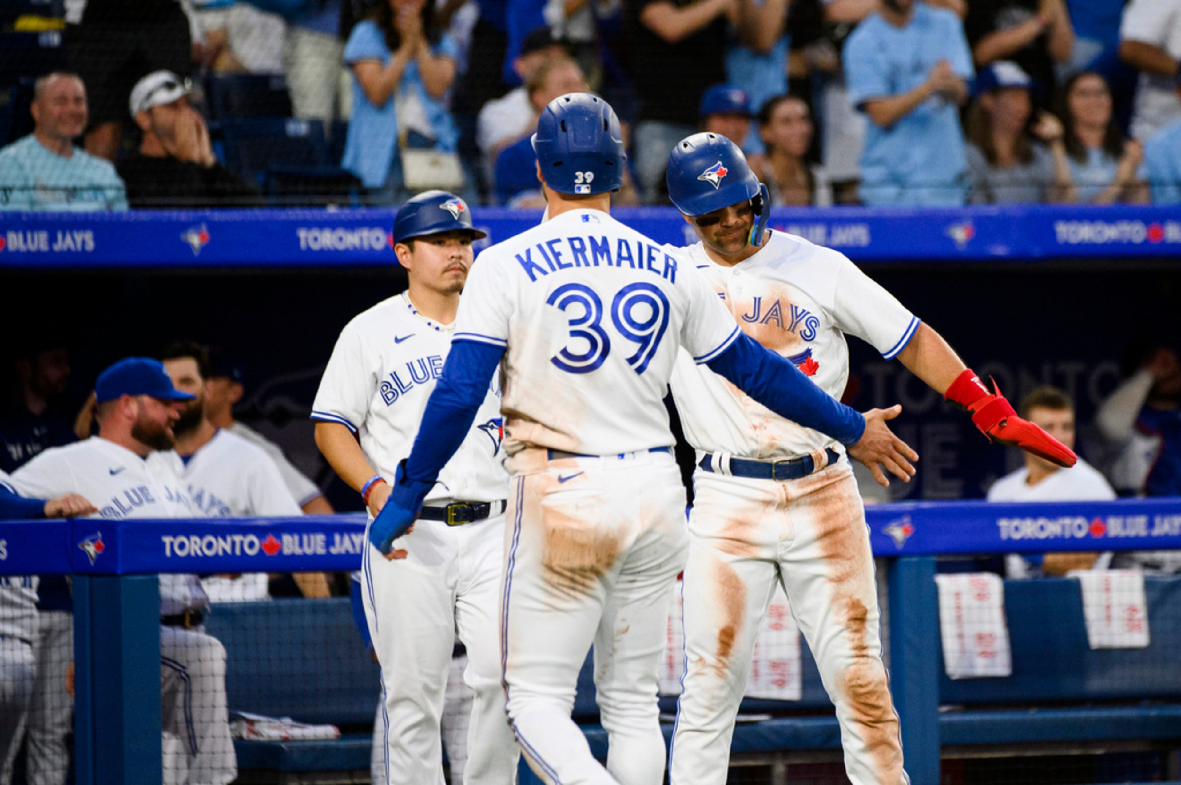 Toronto Blue Jays' Kevin Kiermaier (39) and Whit Merrifield celebrate after scoring against the Atlanta Braves during the fifth inning of a baseball game Friday, May 12, 2023, in Toronto. (Christopher Katsarov/The Canadian Press via AP)