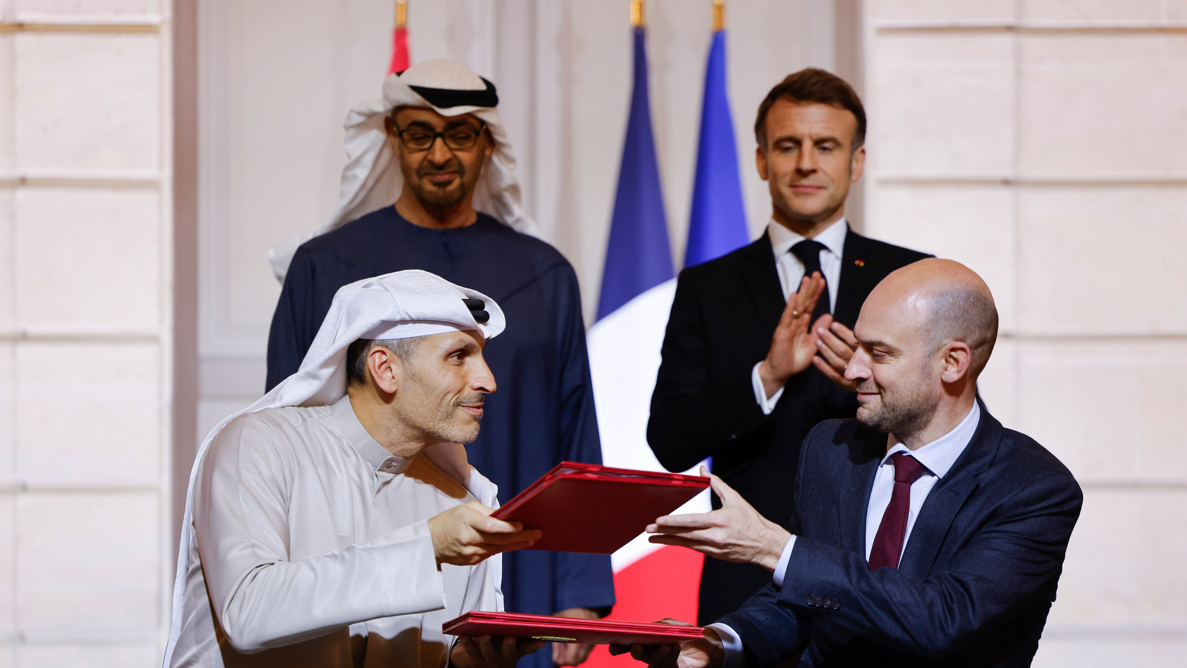FILE -France's President Emmanuel Macron, rear right, and United Arab Emirates President Sheikh Mohamed bin Zayed Al Nahyan, rear left, look on as France's Minister for Europe and Foreign Affairs Jean-Noel Barrot, right, and CEO of Mubadala Investment Company Khaldoon Al Mubarak, left, sign an agreement on AI, at the Elysee Palace, in Paris, Feb. 6, 2025. (Ludovic Marin/Pool Photo via AP), File)