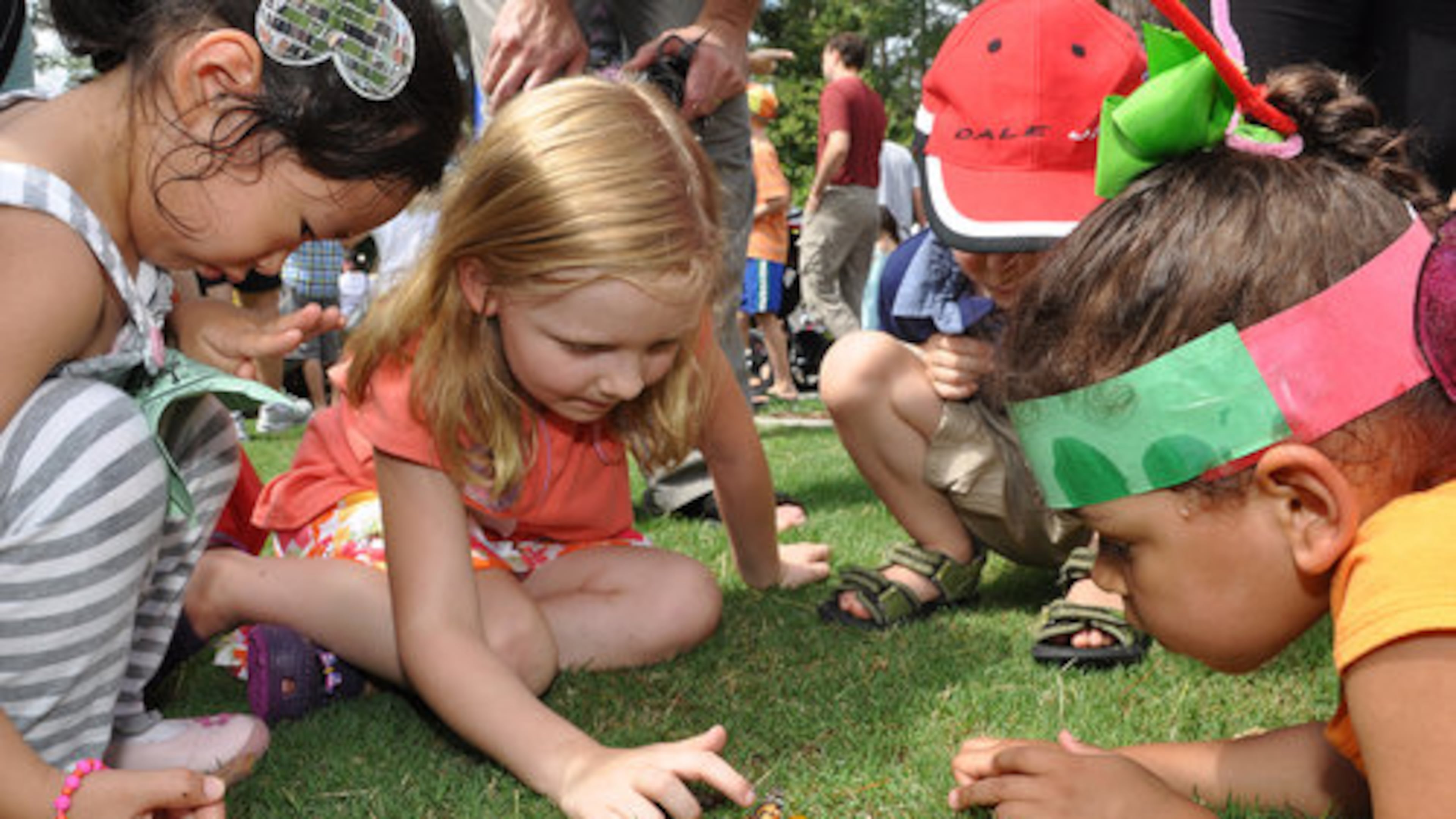 Kids feed a butterfly an orange slice after the release at the Butterfly Festival at the Chattahoochee Nature Center in Roswell on Saturday, July 14.