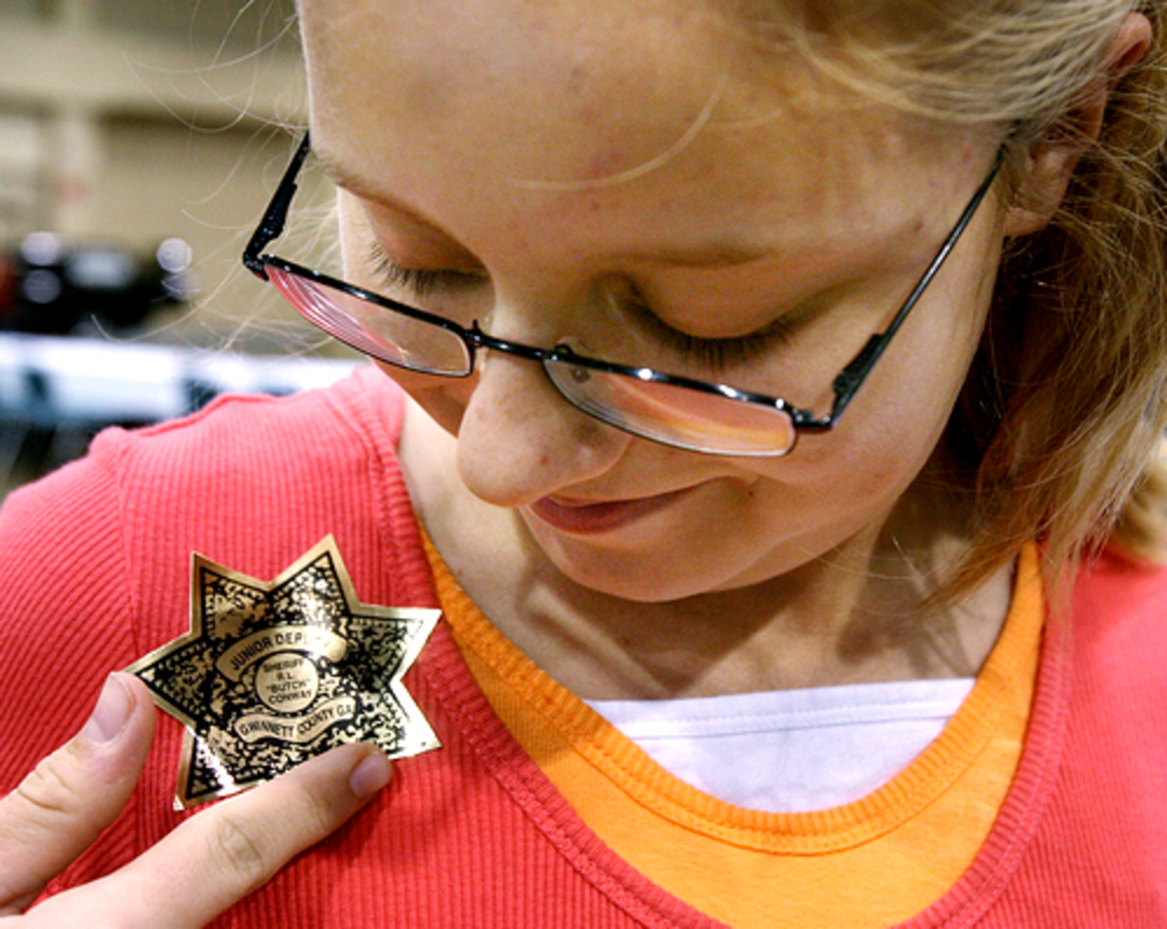 Madison Fender, 10, of Lawrenceville, checks out her stick-on badge courtesy of the Gwinnett County Sheriff's Department's "Avoiding Drugs, Violence and Negative Choices Early" program.
