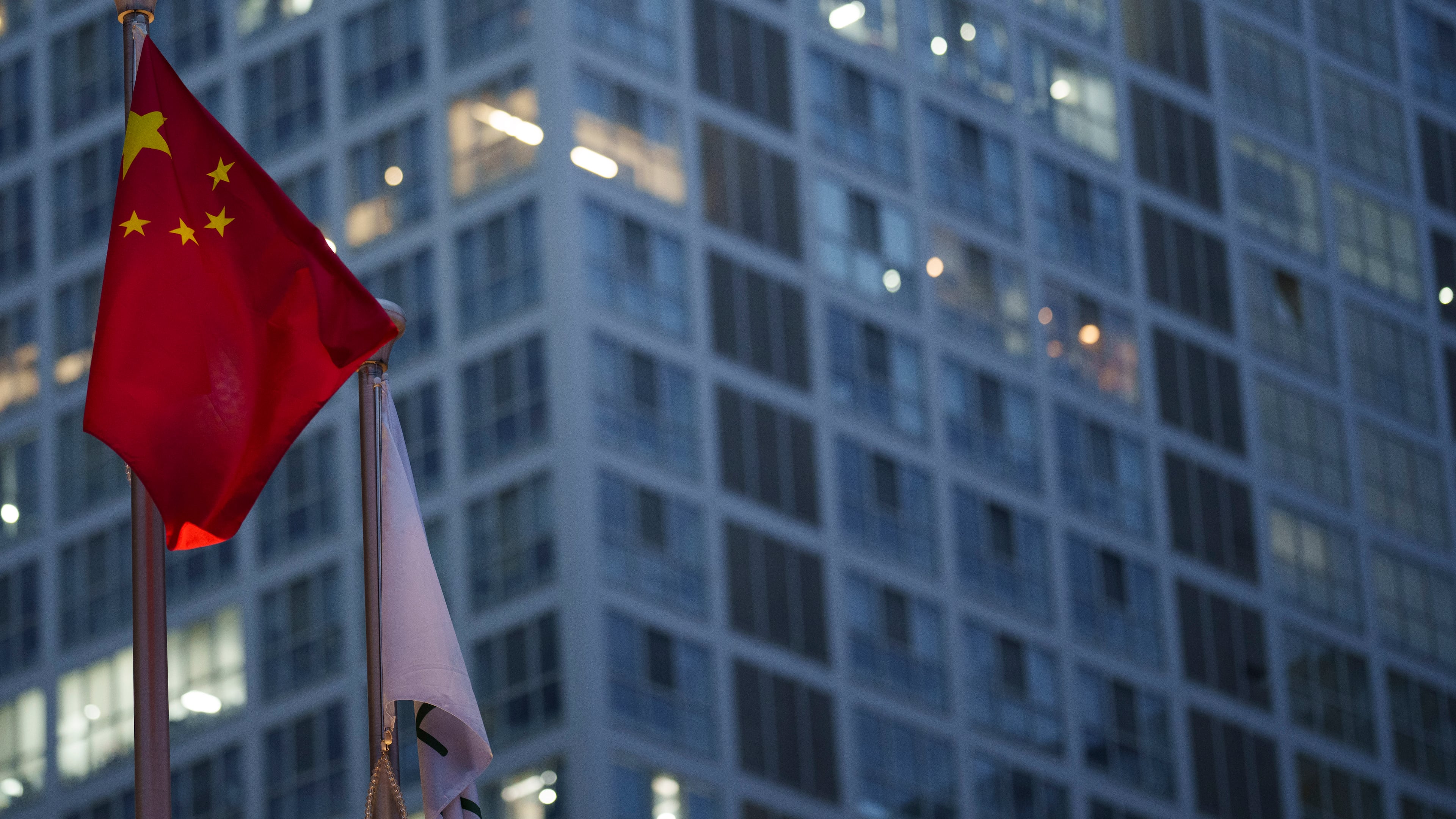 Chinese flag is on display during a ate evening with the background of central business district in Beijing, China, Monday, July 15, 2024. (AP Photo/Vincent Thian)