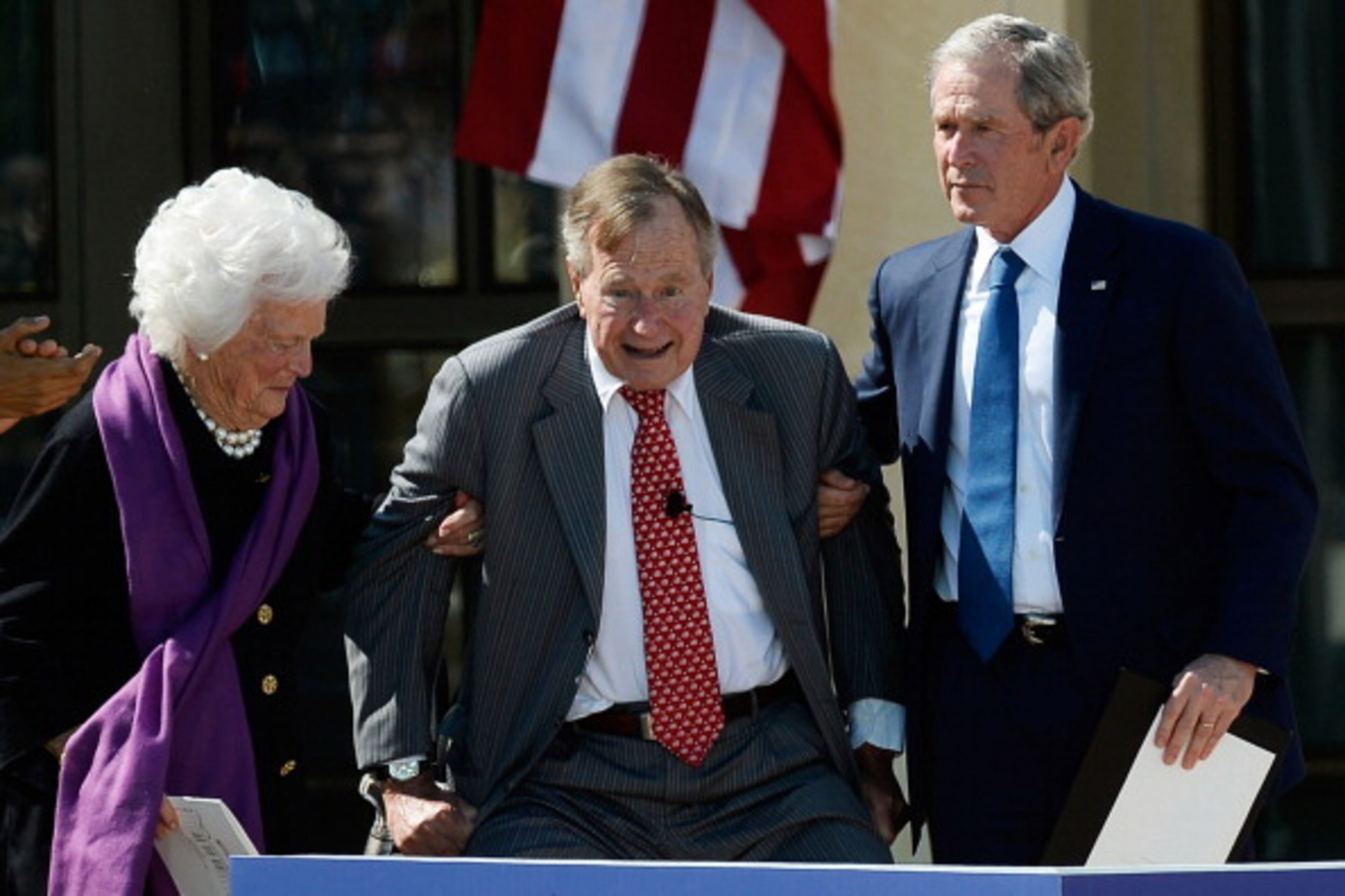 DALLAS, TX - APRIL 25: Former first lady Barbara Bush (L) and former President George W. Bush (R) help up former President George H.W. Bush during the opening ceremony of the George W. Bush Presidential Center April 25, 2013 in Dallas, Texas. The Bush library, which is located on the campus of Southern Methodist University, with more than 70 million pages of paper records, 43,000 artifacts, 200 million emails and four million digital photographs, will be opened to the public on May 1, 2013. The library is the 13th presidential library in the National Archives and Records Administration system. (Photo by Kevork Djansezian/Getty Images)