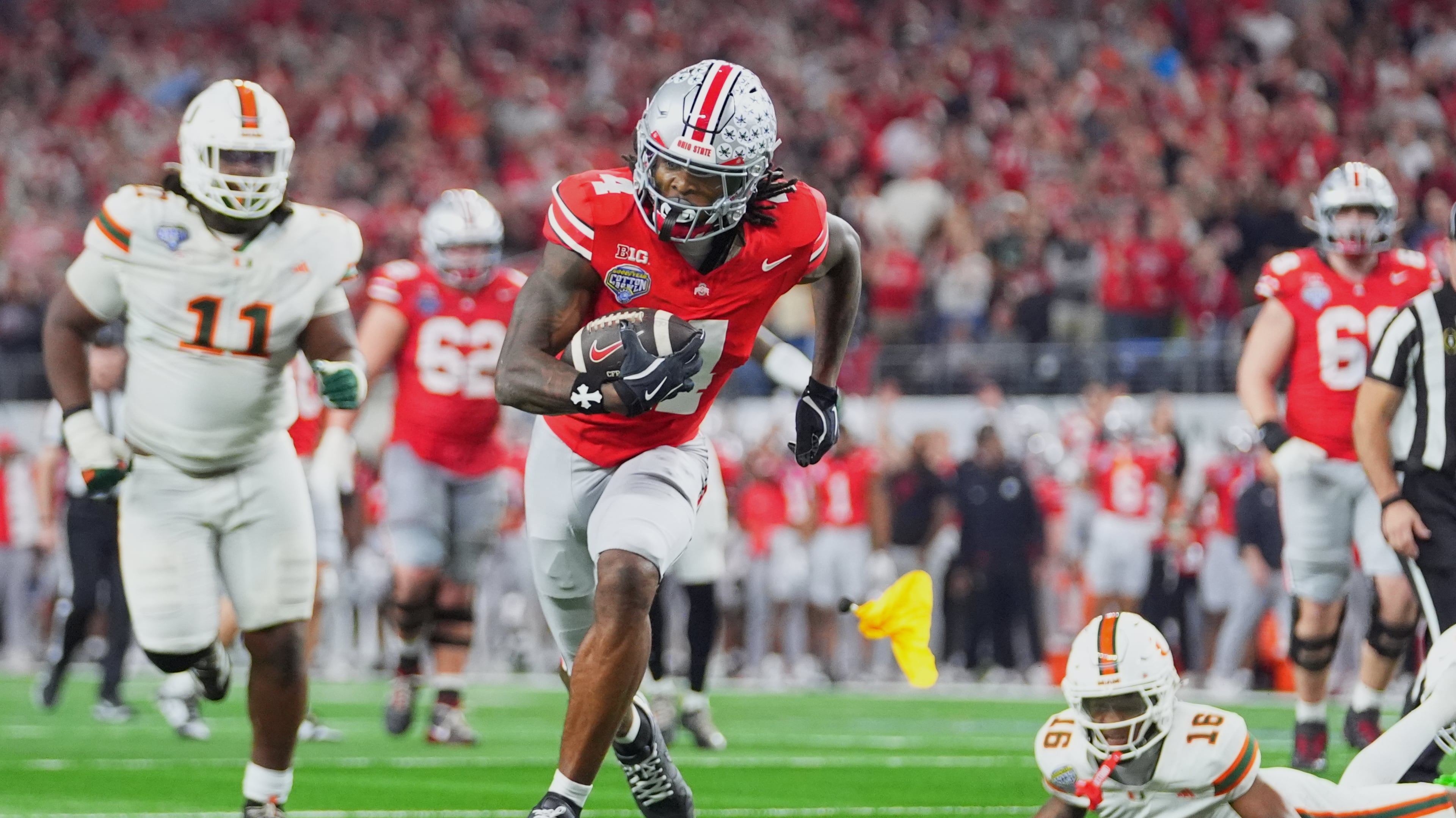 FILE - Ohio State wide receiver Jeremiah Smith, center, gets away from Miami defensive lineman David Blay Jr. (11) and defensive back Ja'Boree Antoine (16) to score a touchdown during the second half of the Cotton Bowl College Football Playoff quarterfinal game Wednesday, Dec. 31, 2025, in Arlington, Texas. (AP Photo/Julio Cortez, File)