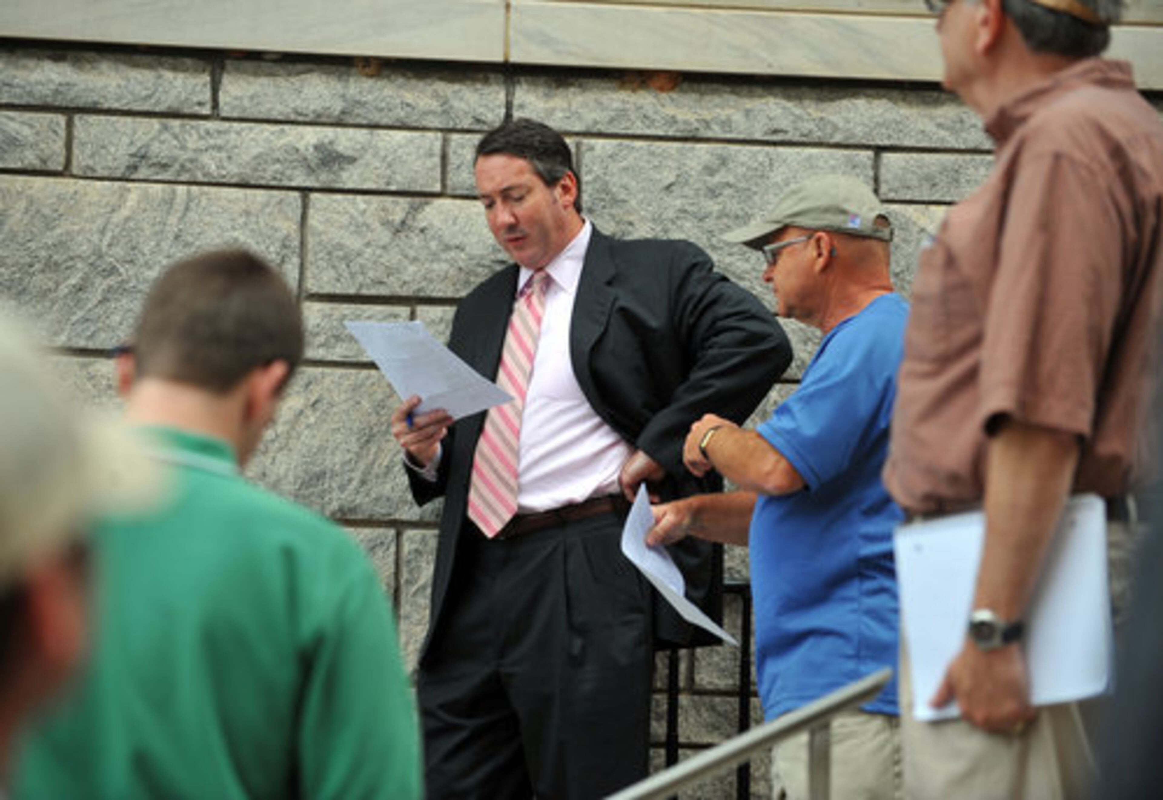 Attorney John Galliagher auctions a property on the courthouse steps in Marietta Tuesday. Galliagher had five other counties to auction properties in on Tuesday.