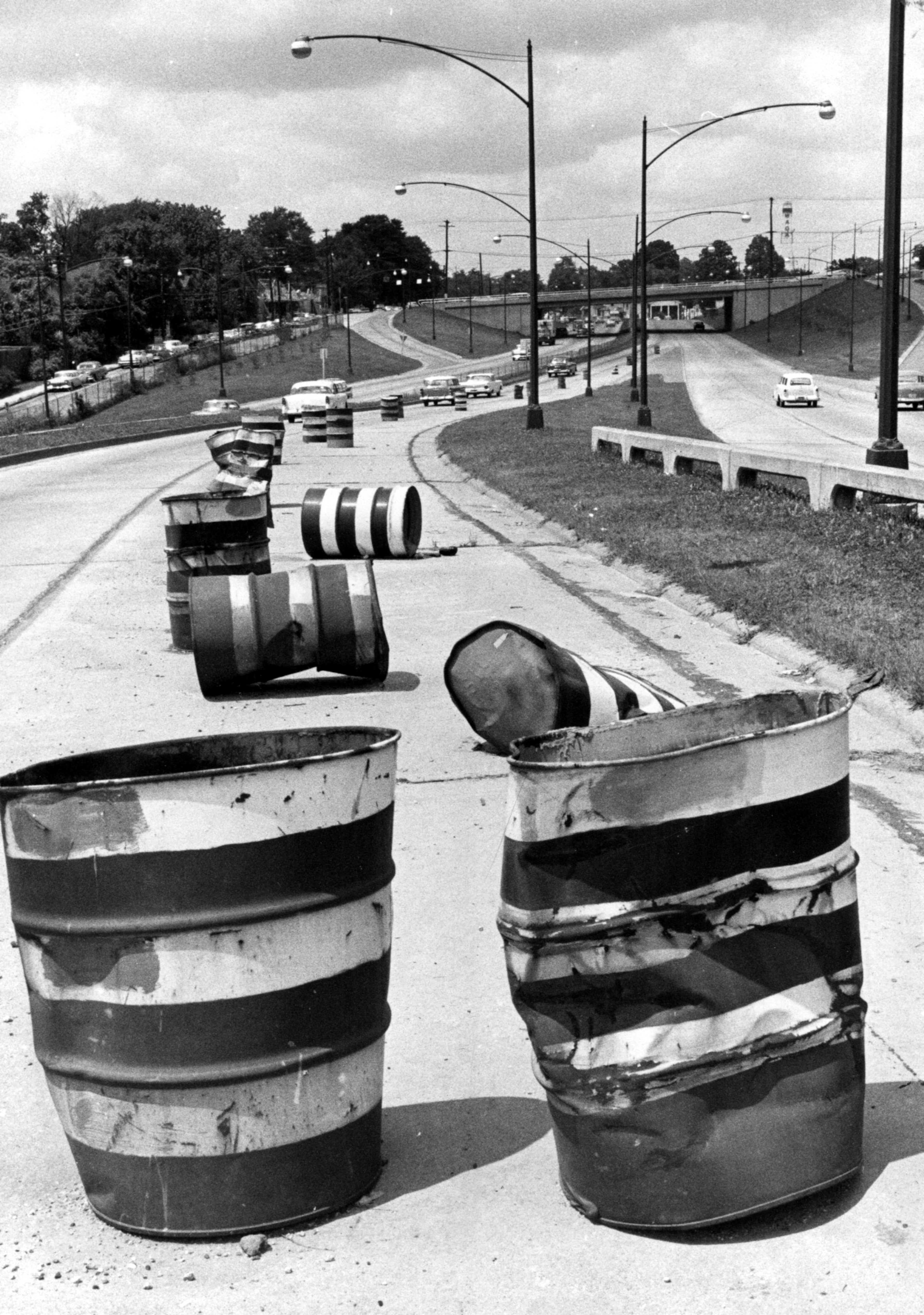 1961 -- A view of the Williams Street entrance to the North Expressway. The battered and beaten barrels lining the entrance will be rolled away in about a week, city construction chief Ray Nixon said. Construction on a new curbing to route traffic from Williams St. onto the Expressway downtown got underway Monday.
