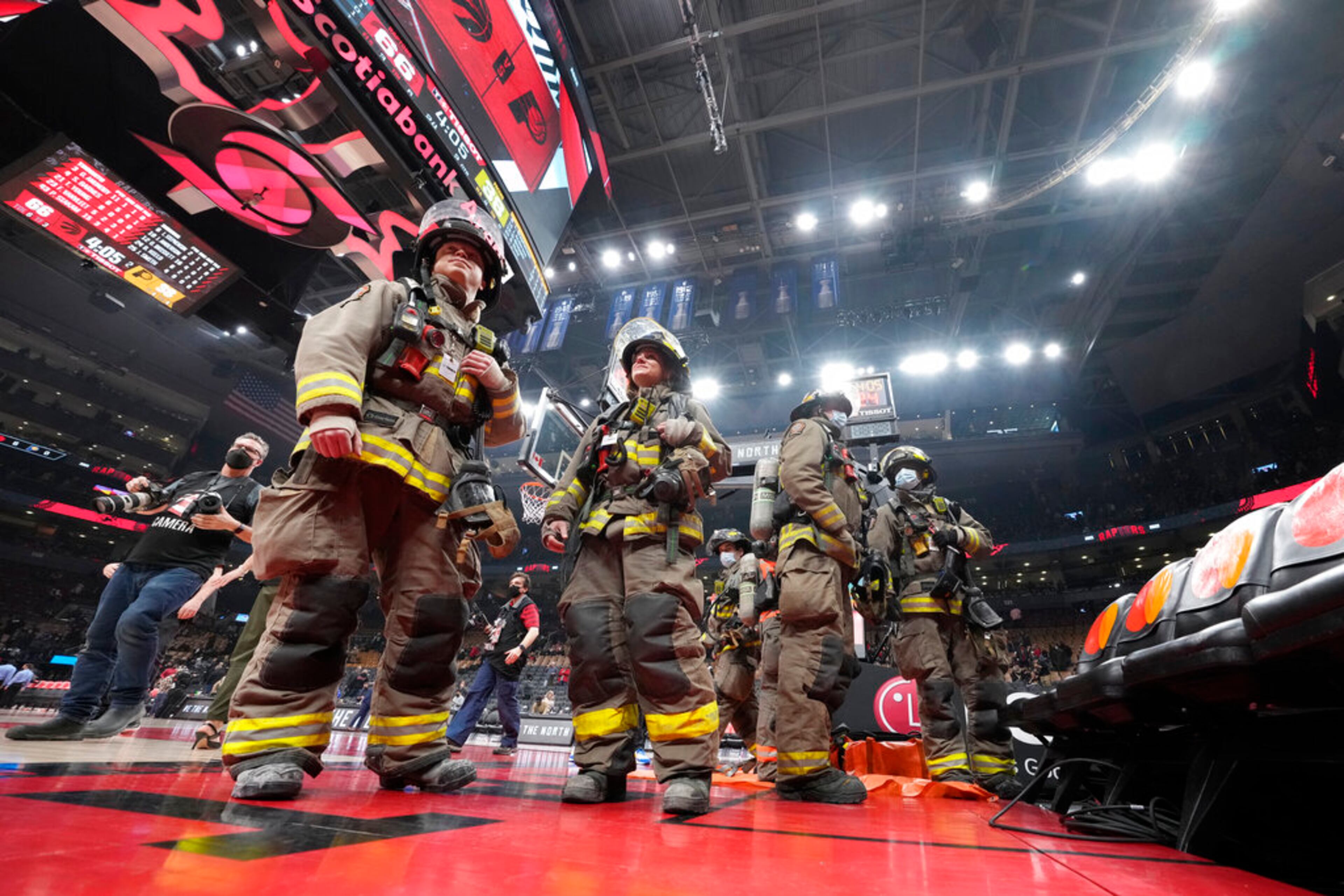 The NBA basketball game is suspended between the Toronto Raptors and the Indiana Pacers as firefighters work to evacuate the building during the first half Saturday, March 26, 2022, in Toronto. (Frank Gunn/The Canadian Press via AP)