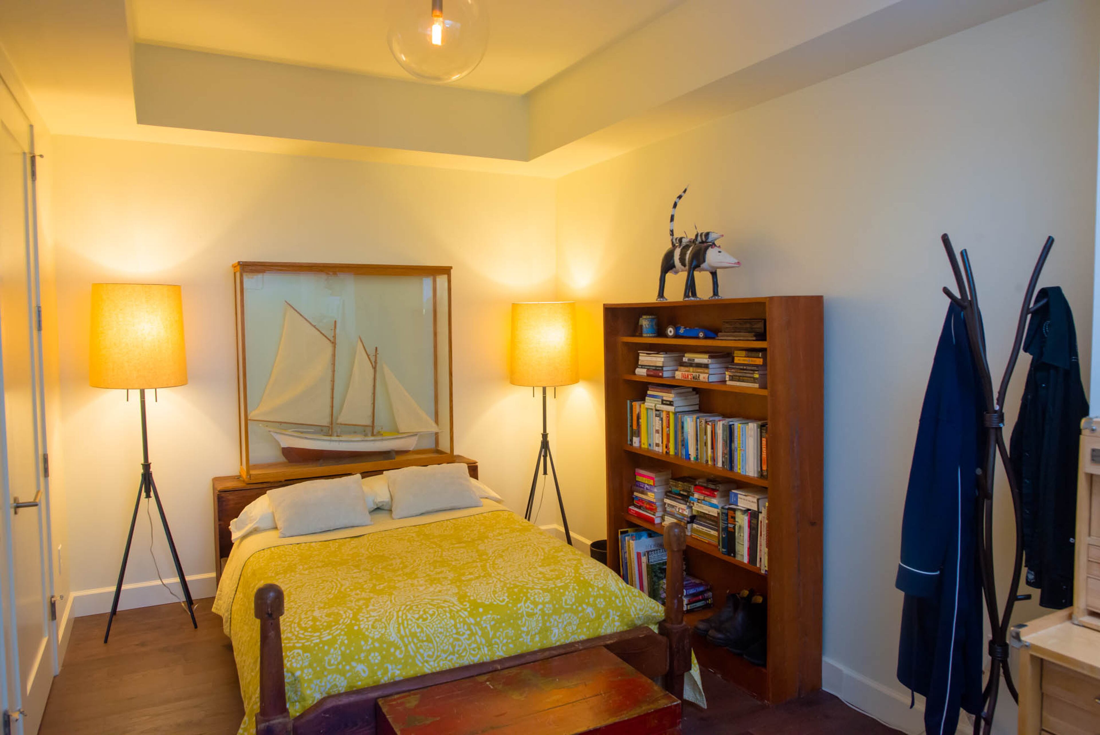 The second guest bedroom of this Atlanta condo features many unique pieces, including the bed, which was hand-carved and built by homeowner Ron Seichrist. The lamps on either side of the bed were purchased at RH. The boat was found by Ron and his wife, Pippa, while they were antiquing. Text by Anna Logan/Fast Copy News Service.