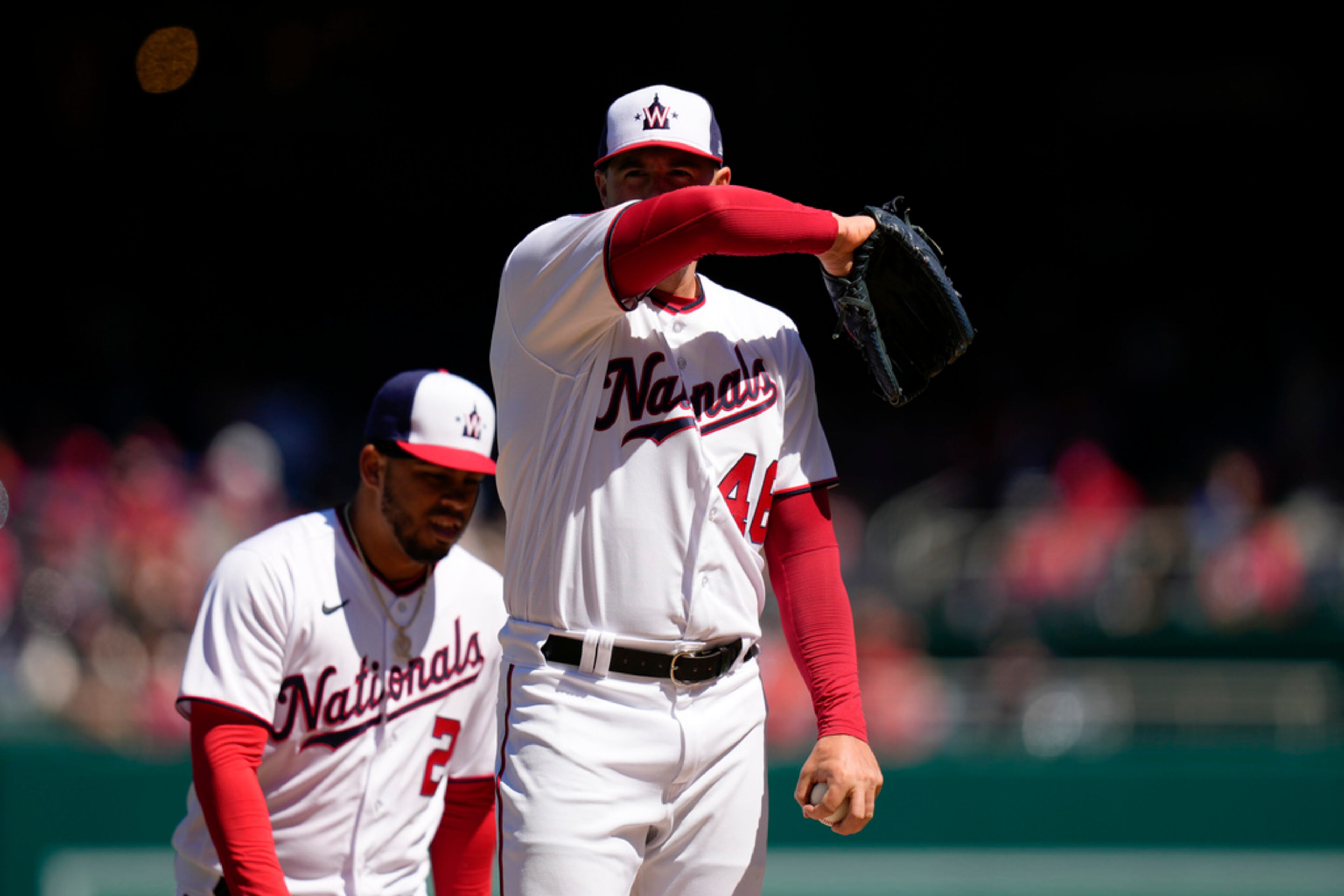 Washington Nationals starting pitcher Patrick Corbin pauses before speaking with pitching coach Jim Hickey during the second inning of an opening day baseball game against the Atlanta Braves at Nationals Park, Thursday, March 30, 2023, in Washington. (AP Photo/Alex Brandon)