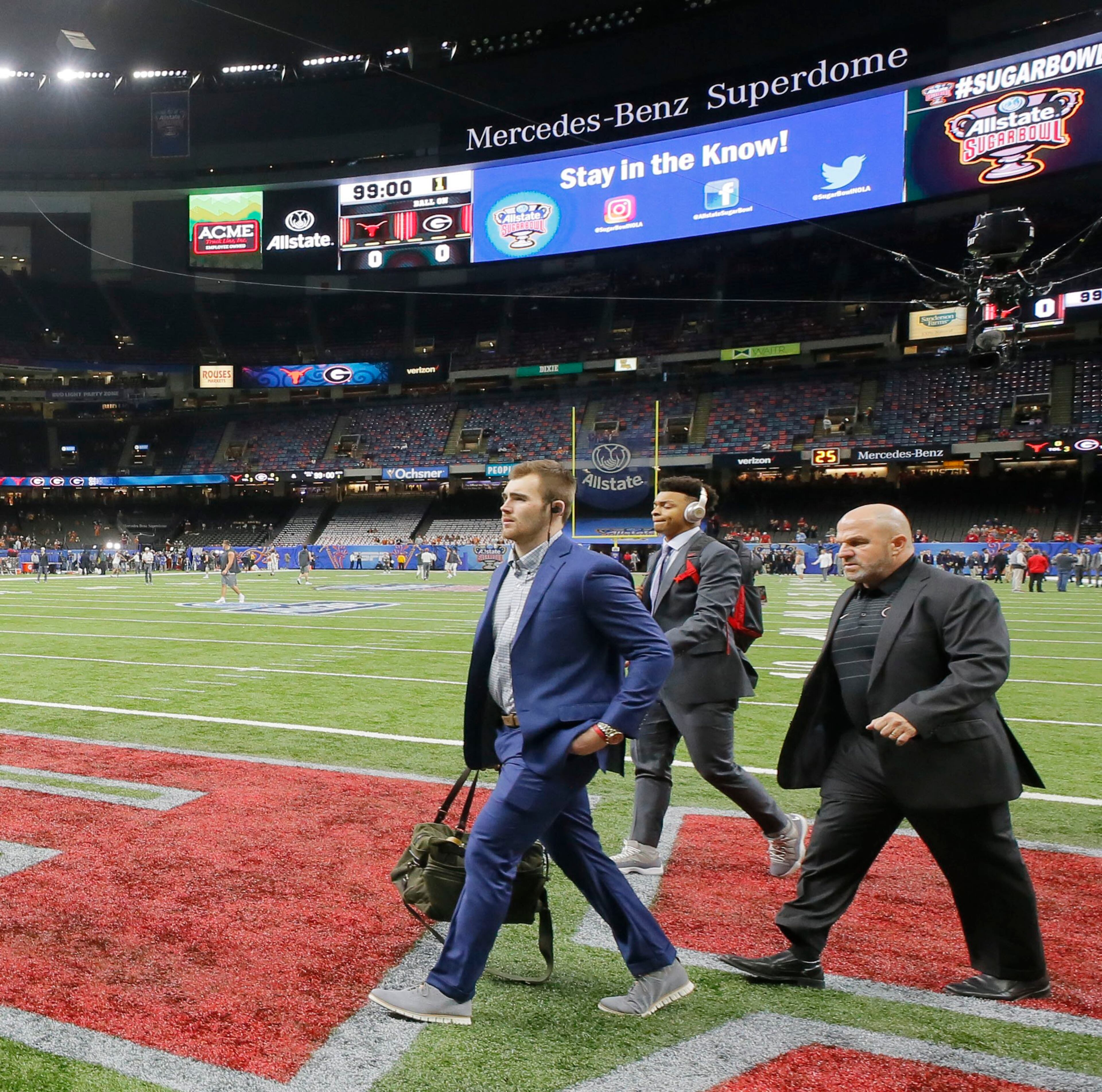 1/1/19 - New Orleans - Georgia players, including quarterback Jake Fromm (left) and Georgia Bulldogs quarterback Justin Fields, cross the field as they arrive at the stadium. Georgia plays Texas in the Allstate Sugar Bowl at Mercedes-Benz Superdome in New Orleans on Jan. 1, 2019. BOB ANDRES / bandres@ajc.com