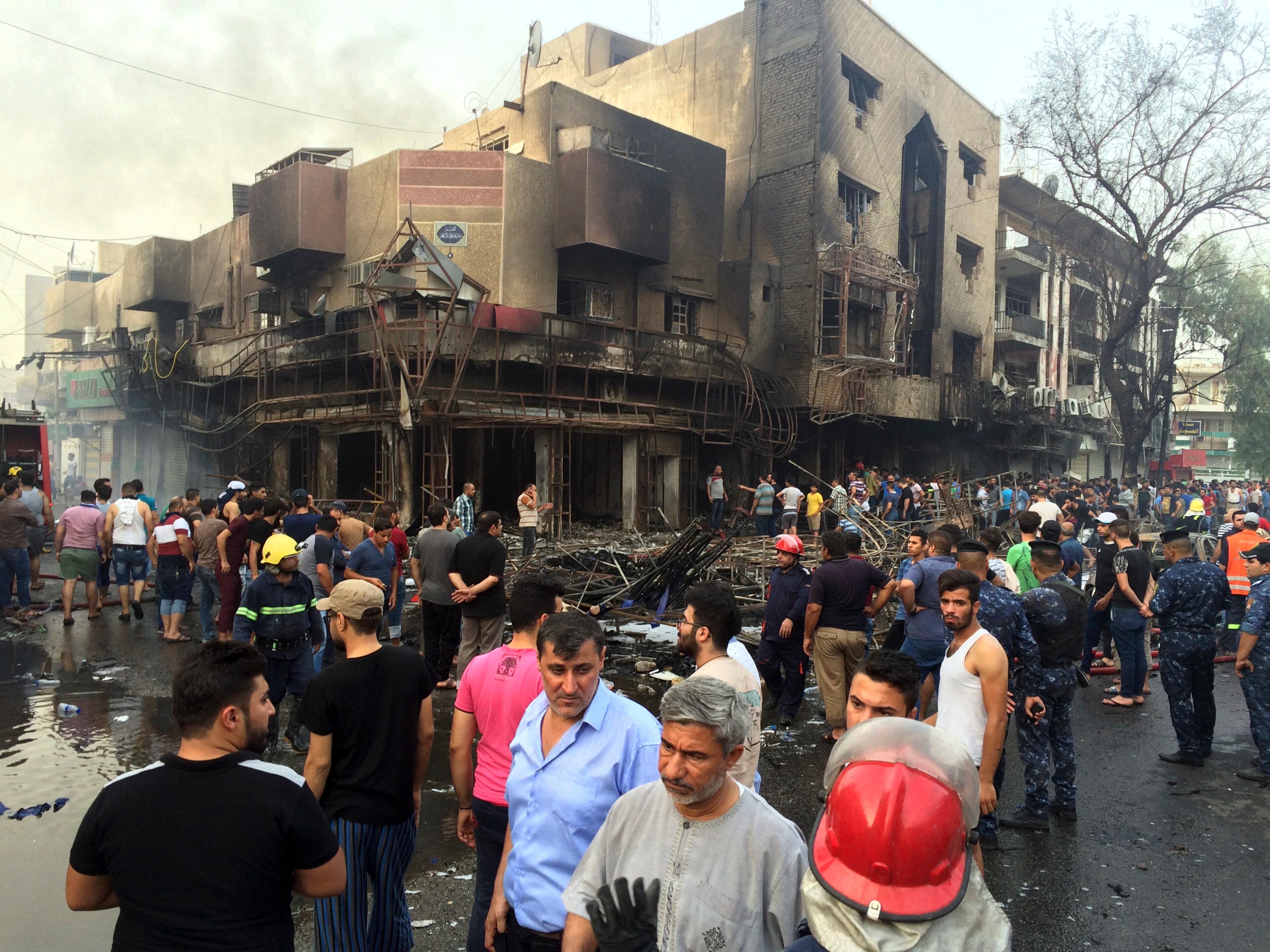 Iraqi security forces and civilians gather at the site after a car bomb at a commercial area in Karada neighborhood, Baghdad, Iraq, Sunday, July 3, 2016. Bombs went off early Sunday in two crowded commercial areas in Baghdad. (AP Photo/Khalid Mohammed)