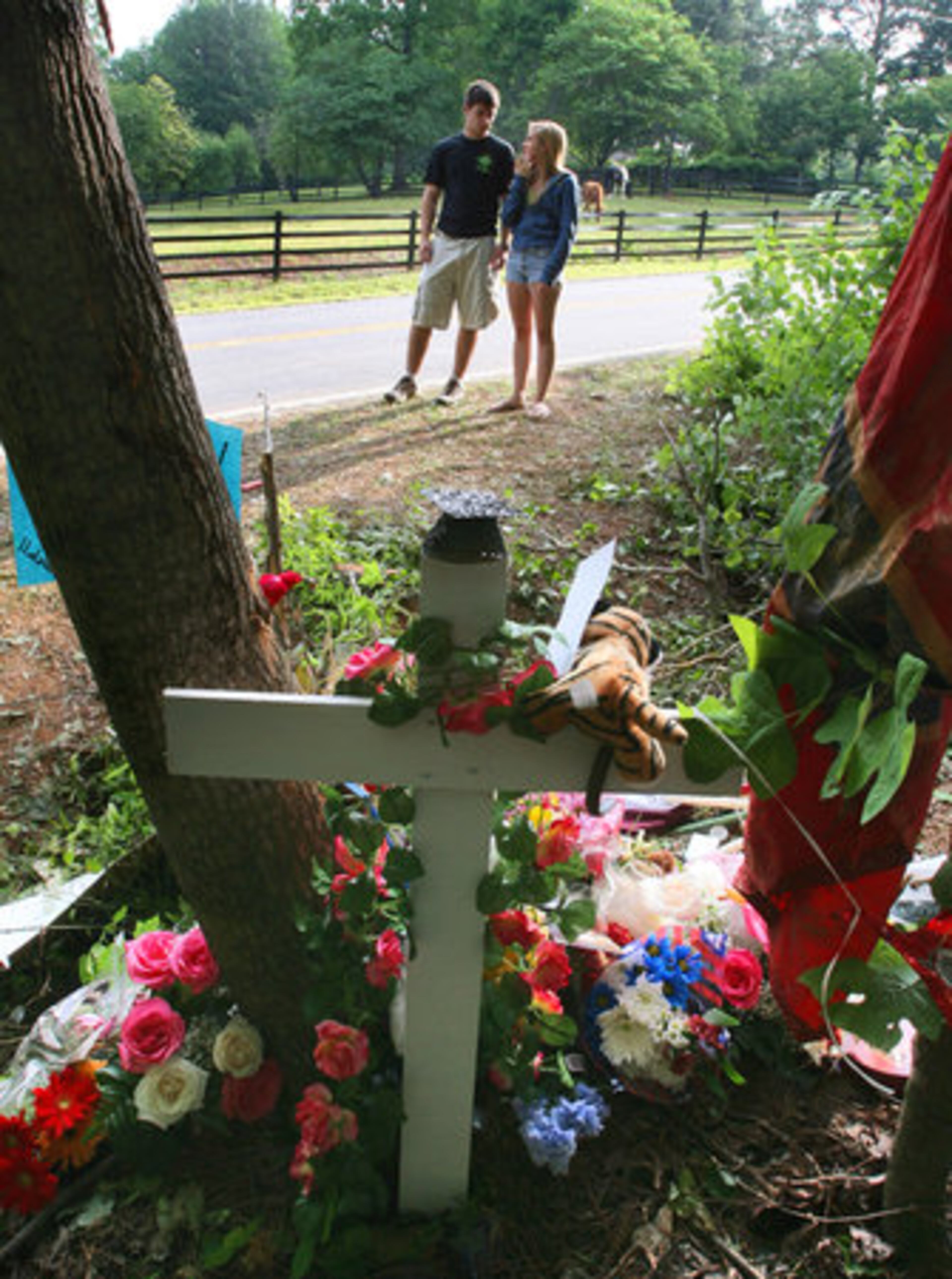 Students from Kennesaw Mountain High School stand at a roadside memorial to Courtney Stroud, 17. Courtney was killed there on Memorial Day in a one-car crash as she attempted to pass a car driven by her best friend, Shani Parker.