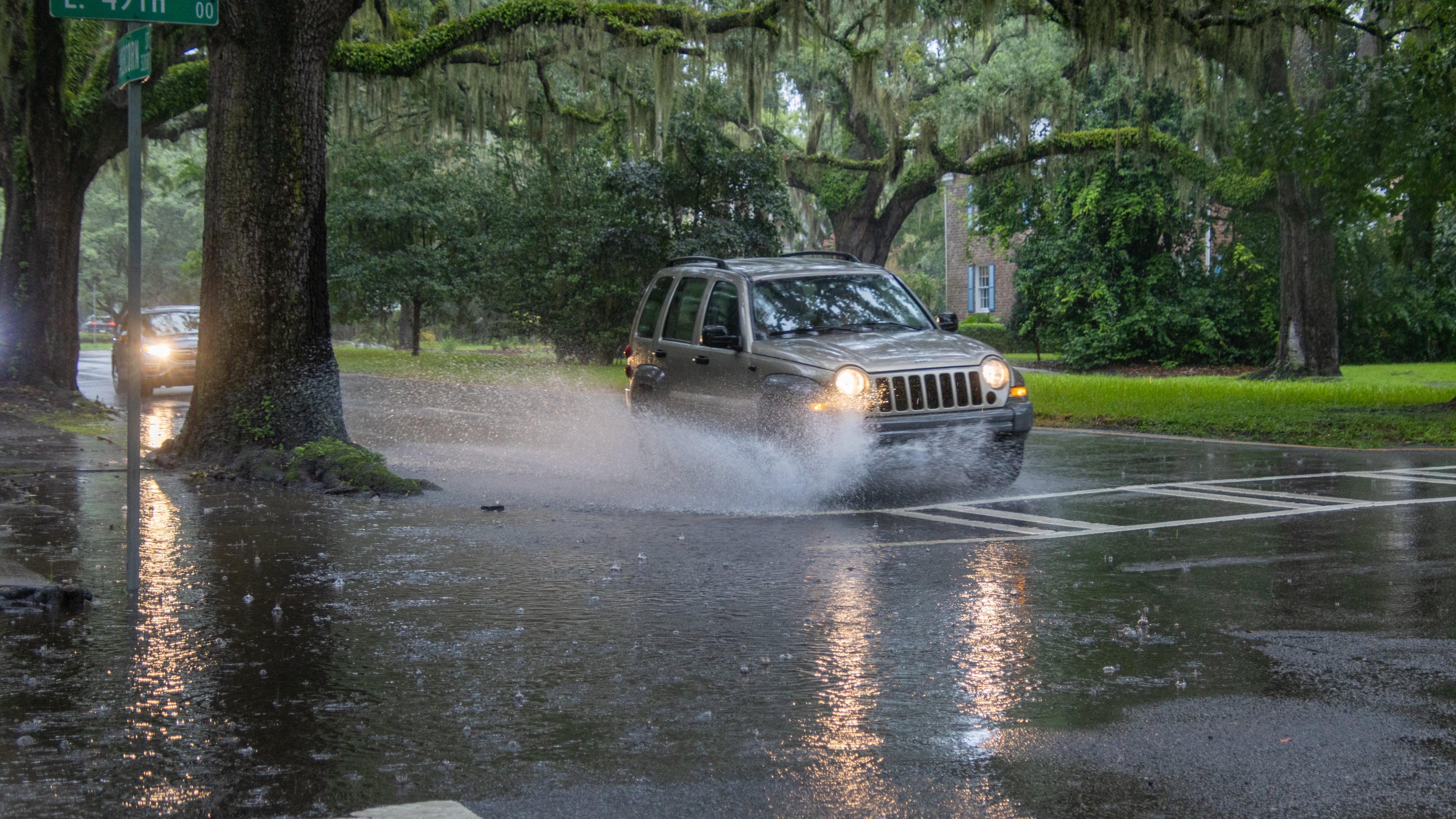 A car drives through a flooded street on Monday, August 5, 2024 in Savannah, GA. (AJC Photo/Katelyn Myrick)