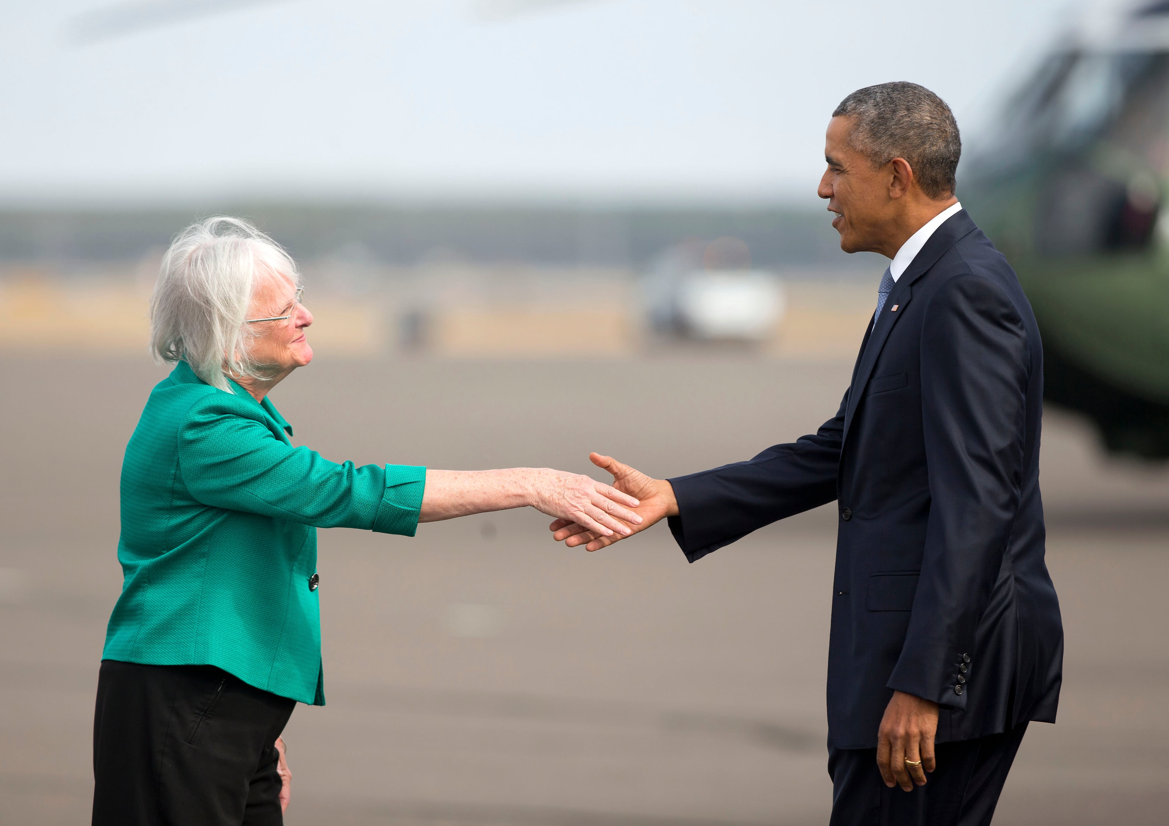 President Barack Obama is greeted on the tarmac by Eugene, Ore. Mayor Kitty Piercy upon his arrival on Air Force One at Mahlon Sweet Field Airport in Eugene, Ore., Friday, Oct. 9, 2015. Obama is traveling to Roseburg, Ore., to meet with families of the victims of the Oct. 1, shooting at Umpqua Community College, as part of a four-day West Coast tour. Obama is also scheduled to attend a fundraiser event later today in Seattle with Sen. Patty Murray, D-Wash. He's is also attending fundraisers in San Francisco and Los Angeles during the four-day visit. (AP Photo/Pablo Martinez Monsivais)