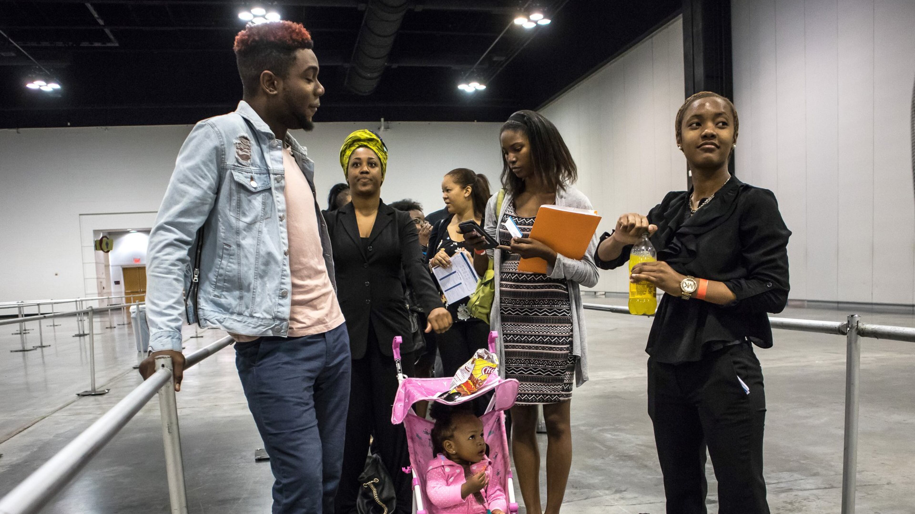 Toni Richardson and her daughter Paris wait in line with Devonte Watson before the doors open at the Airport Community Job Fair in Atlanta. STEVE SCHAEFER / SPECIAL TO THE AJC
