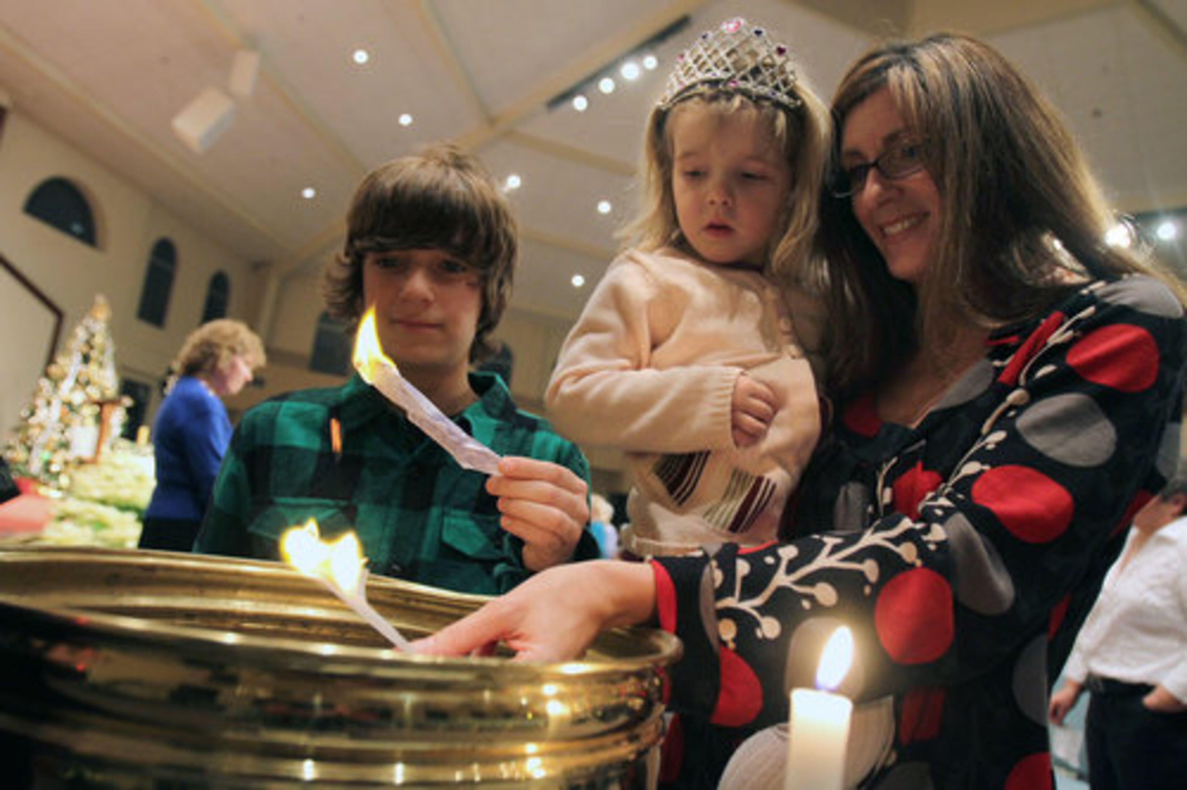 Tracey Sutherland participates in the Burning Bowl Service with her niece Kinsey DonCarlos, 3, and Tate Sutherland, 10 during the annual New Year's Eve Burning Bowl service at Unity North Atlanta Church in Marietta Saturday, Dec. 31, 2010. The ceremony is completed on New Year's Eve. Participants write down their experiences, conflicts, or unhappiness of the past year they wish to release. This ritual creates the space within necessary for the new.