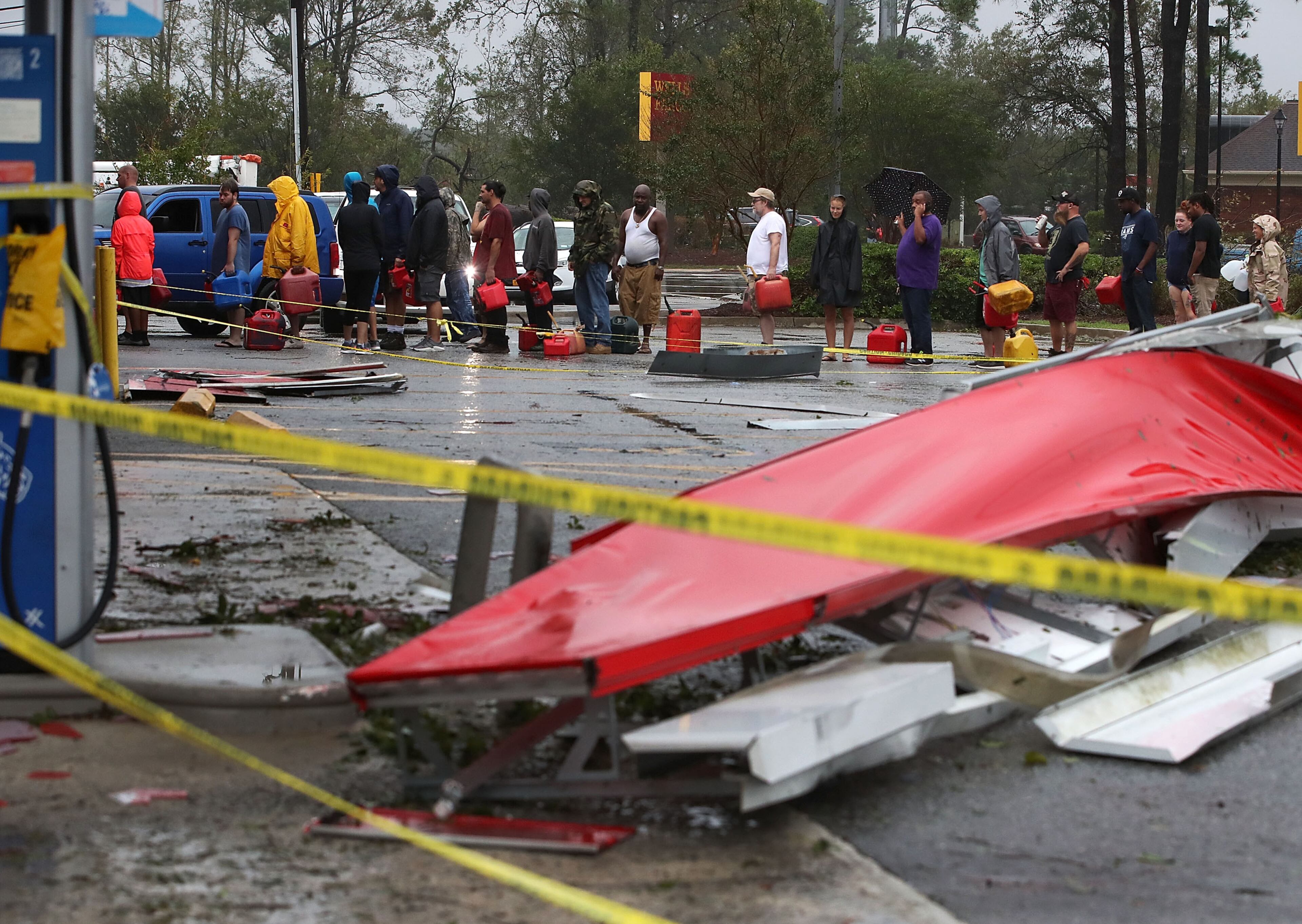 WILMINGTON, NC - SEPTEMBER 15: People wait in line to fill up their gas cans at a gas station that was damaged when Hurricane Florence hit the area, on September 15, 2018 in Wilmington, North Carolina. Hurricane Florence made landfall in North Carolina as a Category 1 storm Friday and at least five deaths have been attributed to the storm, which continues to produce heavy rain and strong winds extending out nearly 200 miles. (Photo by Mark Wilson/Getty Images)