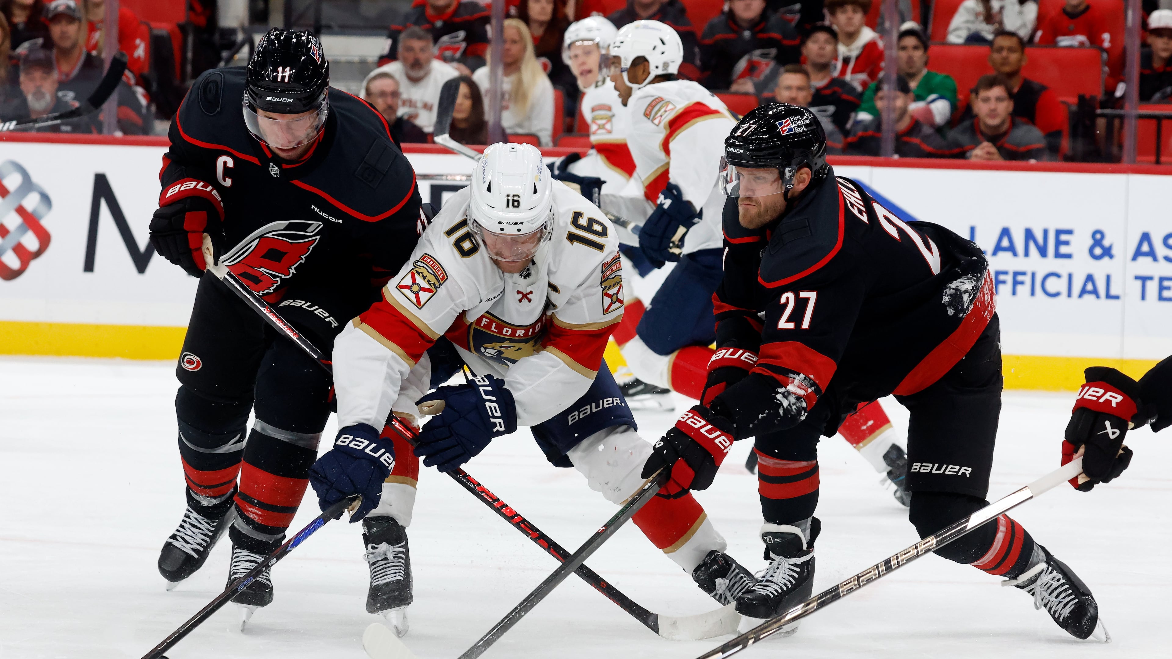 Florida Panthers' Aleksander Barkov (16) battles for the puck between Carolina Hurricanes' Jordan Staal, left, and Nikolaj Ehlers (27) during the third period of an NHL hockey game in Raleigh, N.C., Tuesday, Sept. 29, 2026. (AP Photo/Karl DeBlaker)