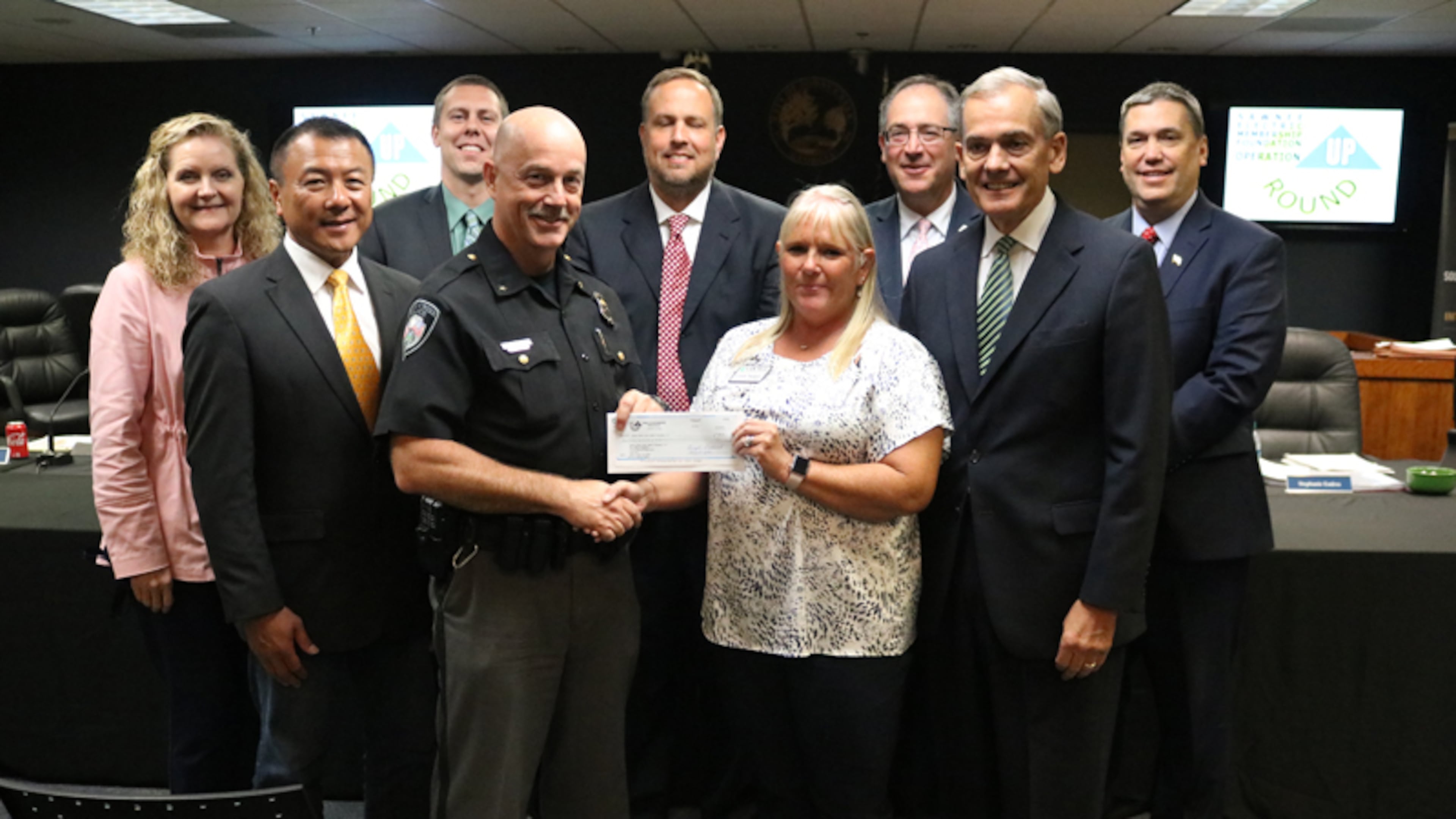 The Sawnee Electric Membership Foundation awards a $7,800 grant to the Johns Creek Public Safety Foundation: (back row) City Council members Stephanie Endres, Jay Lin, Chris Coughlin and John Bradberry; Mayor Mike Bodker; City Council Member Lenny Zaprowski; (front row) Police Chief Ed Densmore; Cindy Badgett, Sawnee EMC; City Council Member Steve Broadbent. CITY OF JOHNS CREEK