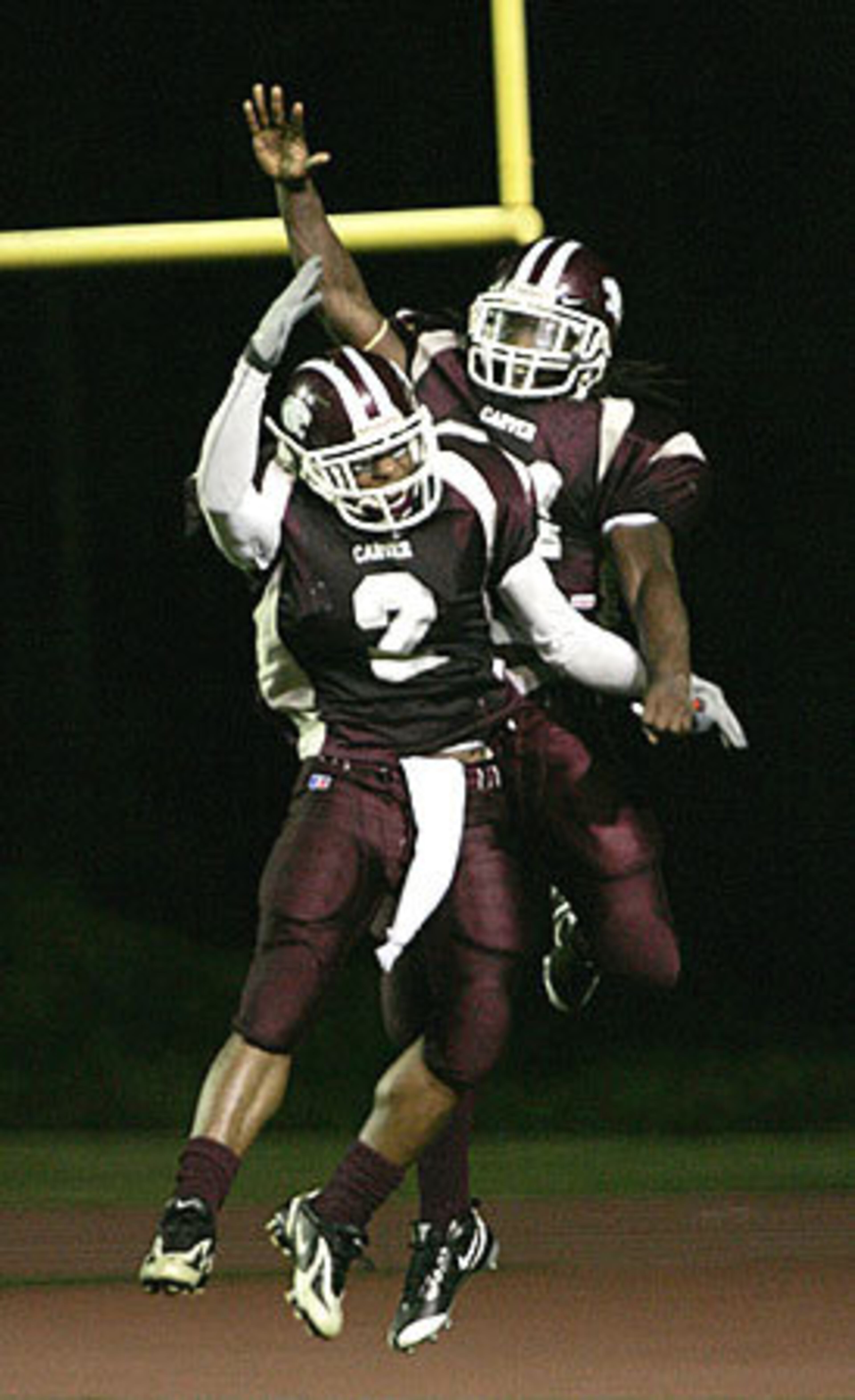 Carver Demond Dennis (rear) celebrates his first-half touchdown with Joel White (2).