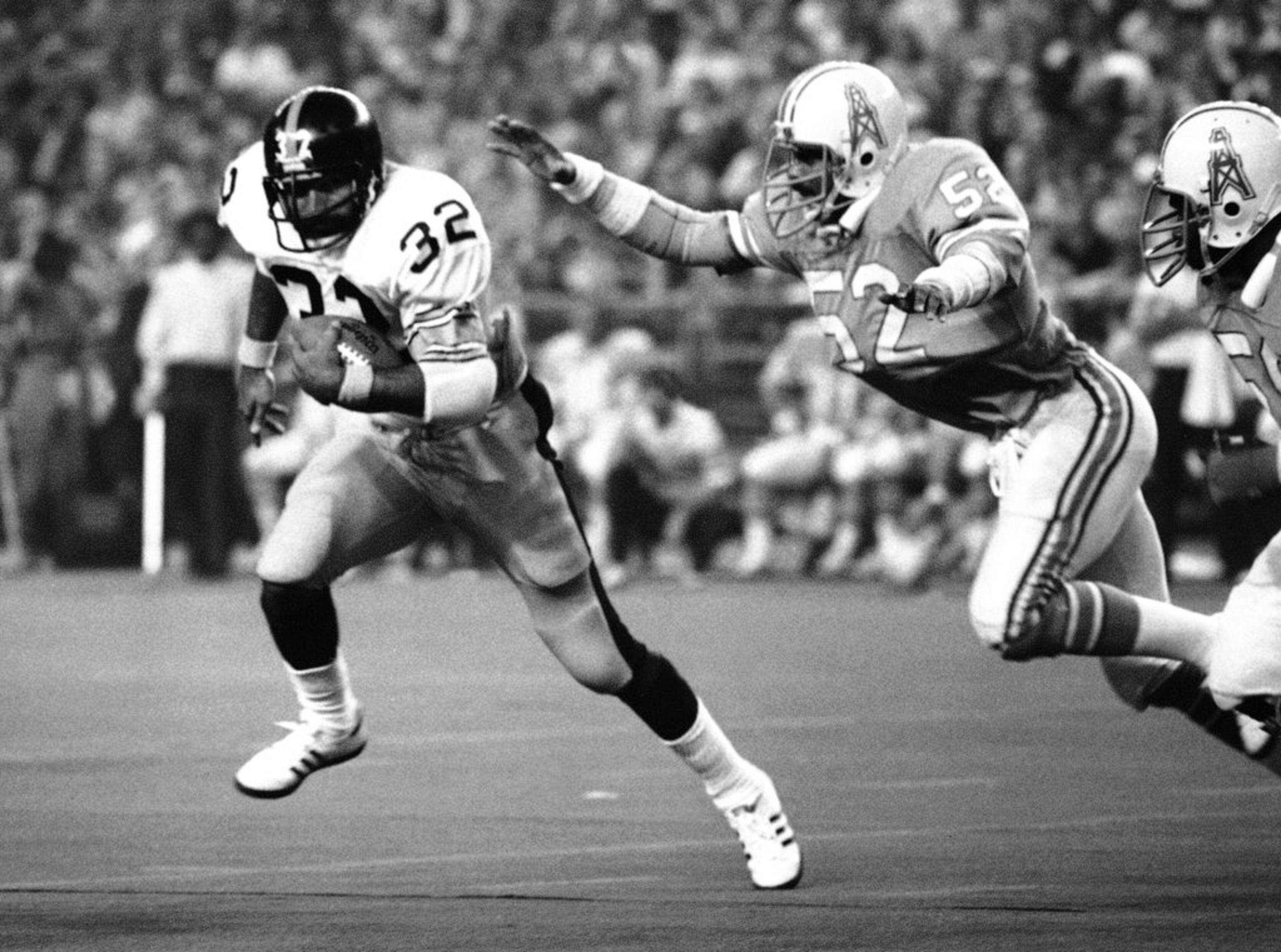 FILE - In this Dec. 3, 1978, file photo, Pittsburgh Steelers running back Franco Harris (32) picks up 10 yards as he turns the corner as Houston Oilers' Robert Brazile (52) makes a dive to latch on to Harris to make the stop, during an NFL football game in Houston. Brazile was elected to the Pro Football Hall of Fame on Saturday, Feb. 3, 2018. (AP Photo/Ed Kolenovsky, File)