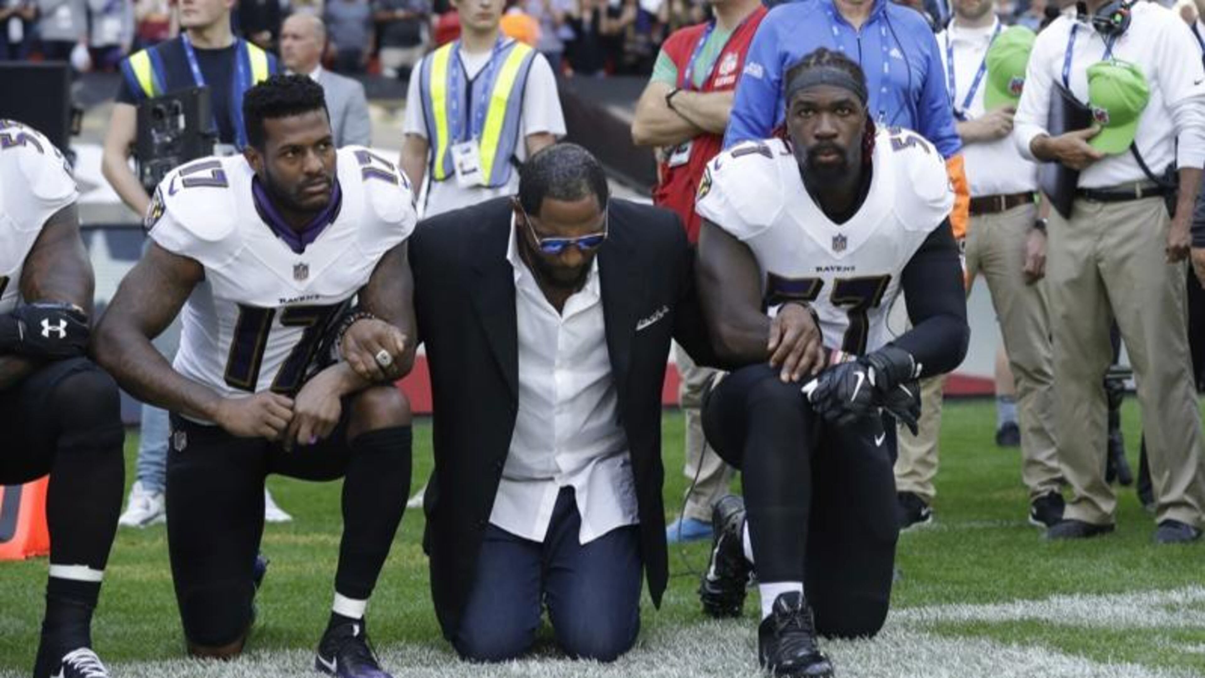 Baltimore Ravens players lock arms and kneel down during the playing of the U.S. national anthem before an NFL football game against the Jacksonville Jaguars at Wembley Stadium in London, Sunday Sept. 24, 2017.