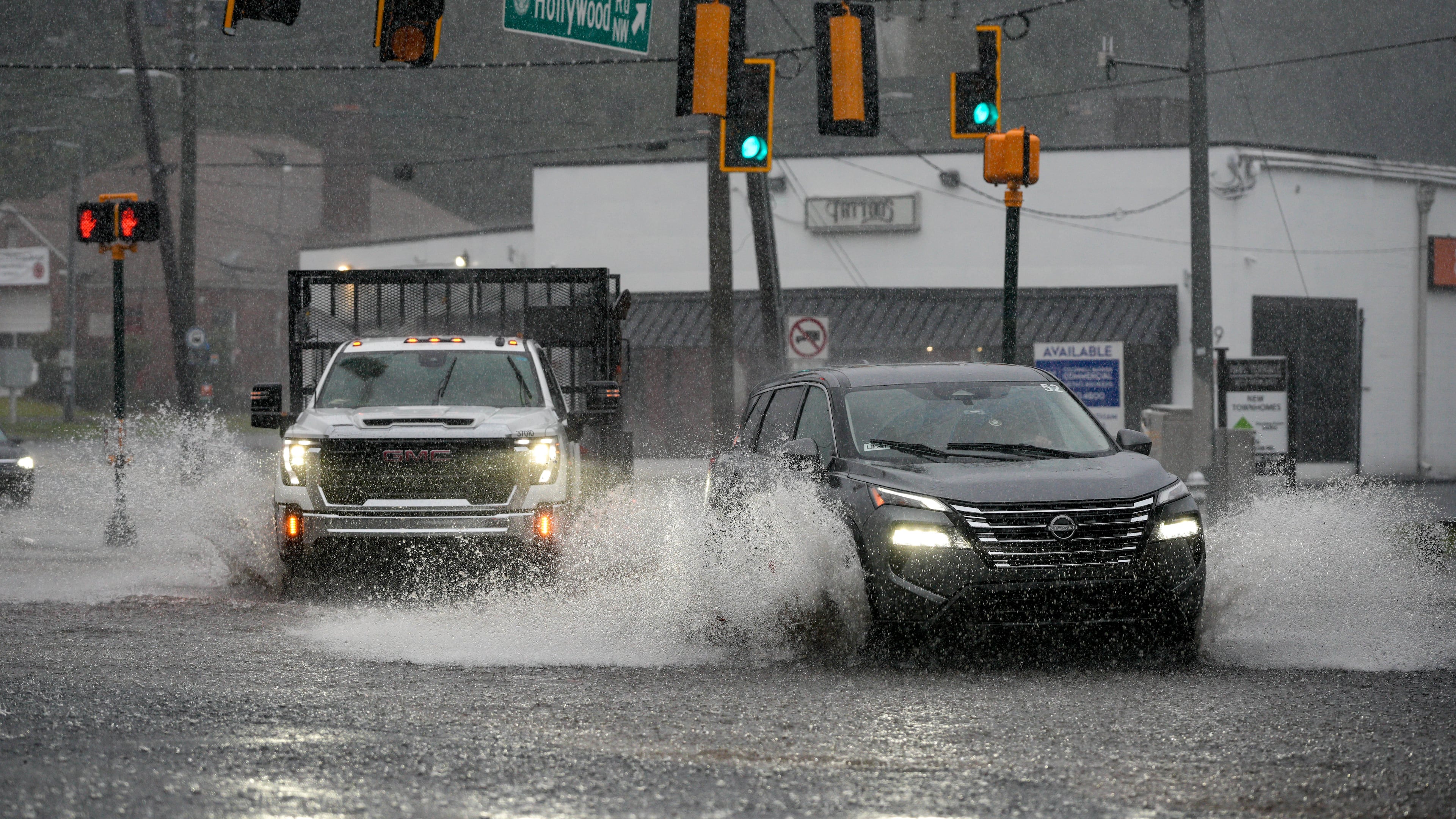 Motorists drive through a flooded street in northwest Atlanta on Saturday, Sept. 12, 2026. (Ben Hendren for The Atlanta Journal-Constitution)