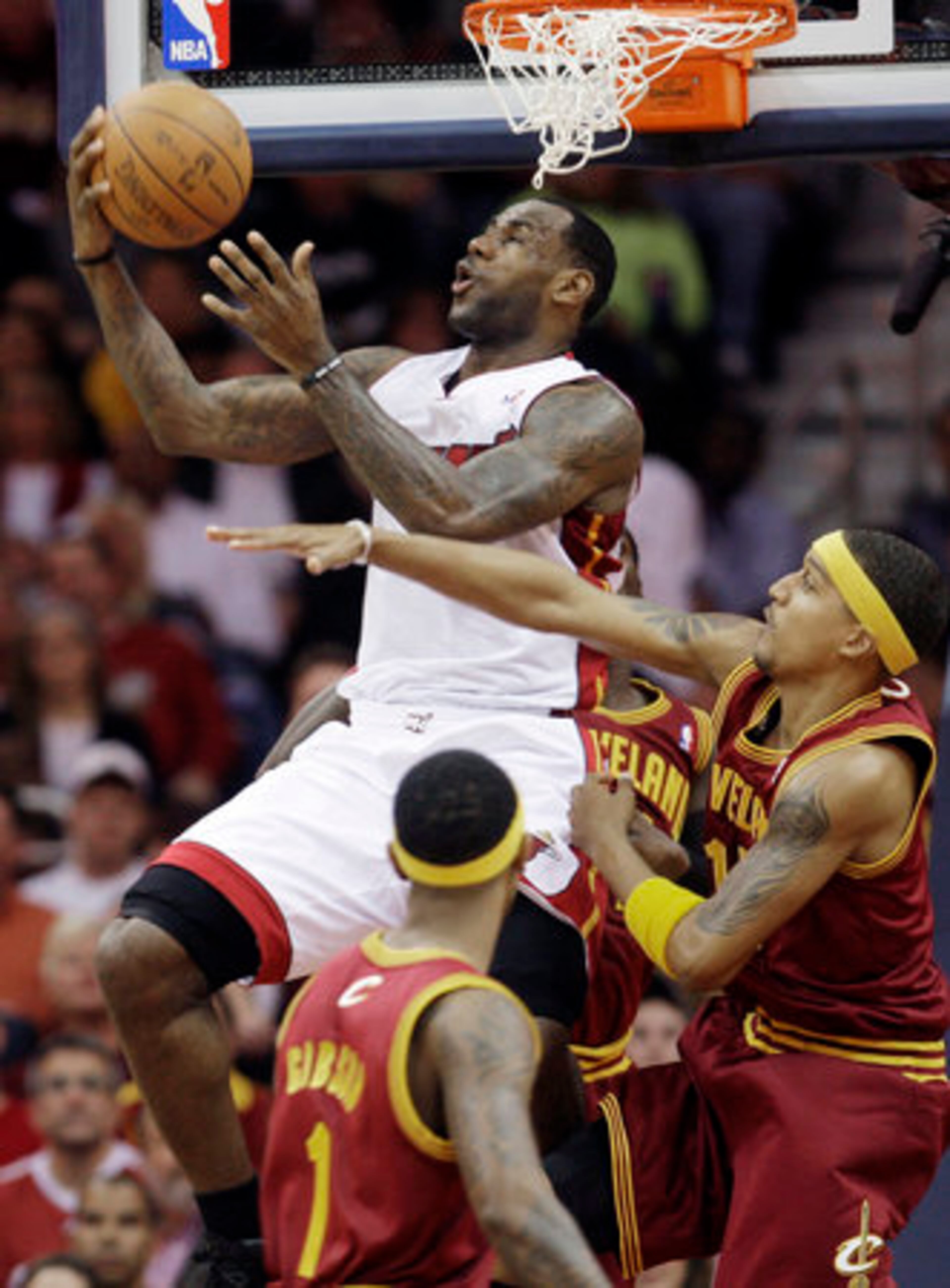 Miami Heat forward LeBron James, top, jumps to the basket against the Cleveland Cavaliers in the first quarter in an NBA basketball game Thursday, Dec. 2, 2010, in Cleveland.