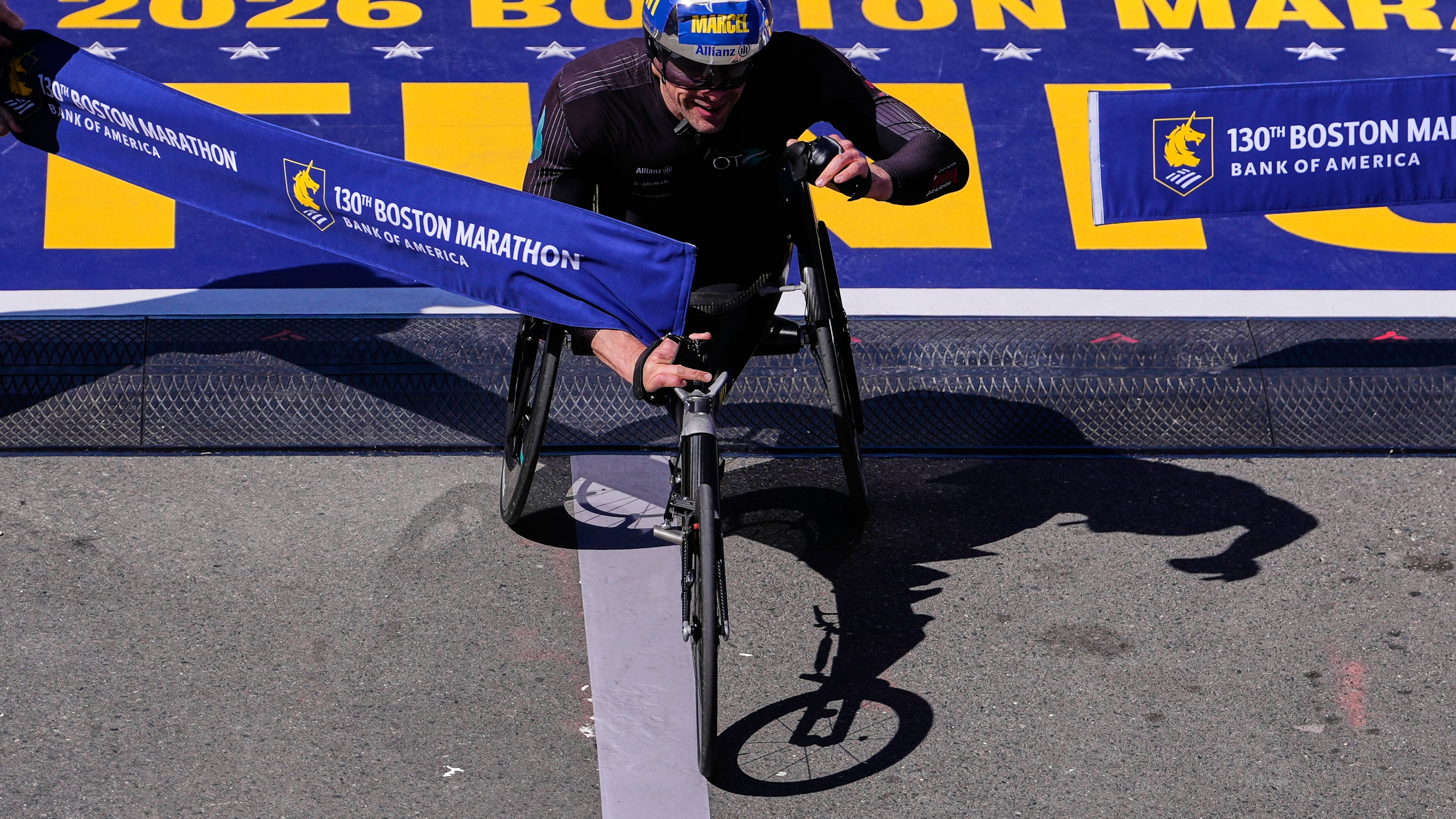 Marcel Hug, of Switzerland, breaks the tape to win the men's wheelchair division at the Boston Marathon, Monday, April 20, 2026, in Boston. (AP Photo/Charles Krupa)