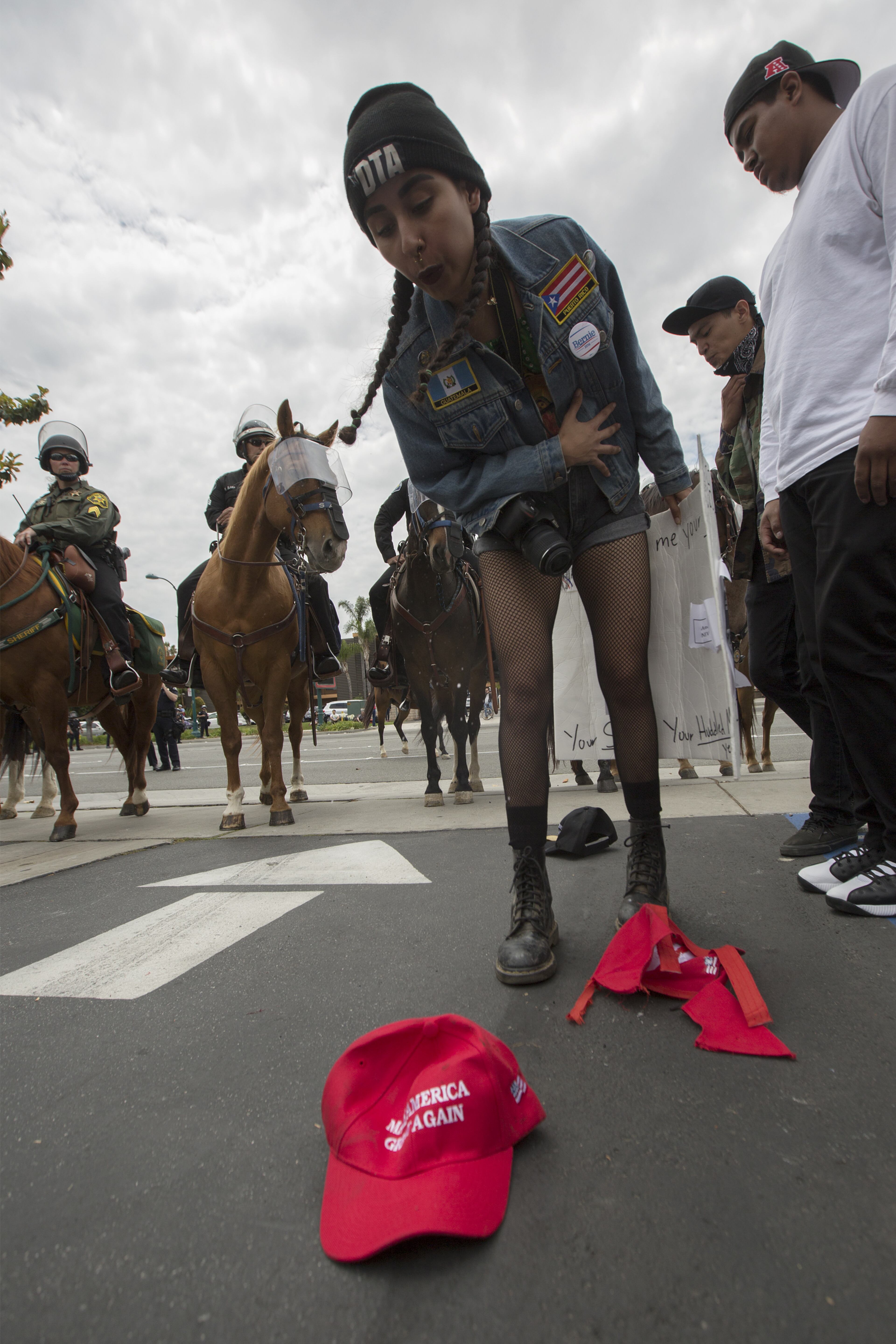 ANAHEIM, CA - MAY 25: An anti-Donal Trump protester spits on pro-Trump hat outside a campaign rally by presumptive GOP presidential candidate at the Anaheim Convention Center on May 25, 2016 in Anaheim, California. Previous visits by the candidate to Orange County have sparked in protests that resulted in some arrests. The presidential candidates are campaigning in Southern California for the June 7 California primary. (Photo by David McNew/Getty Images) ***BESTPIX***