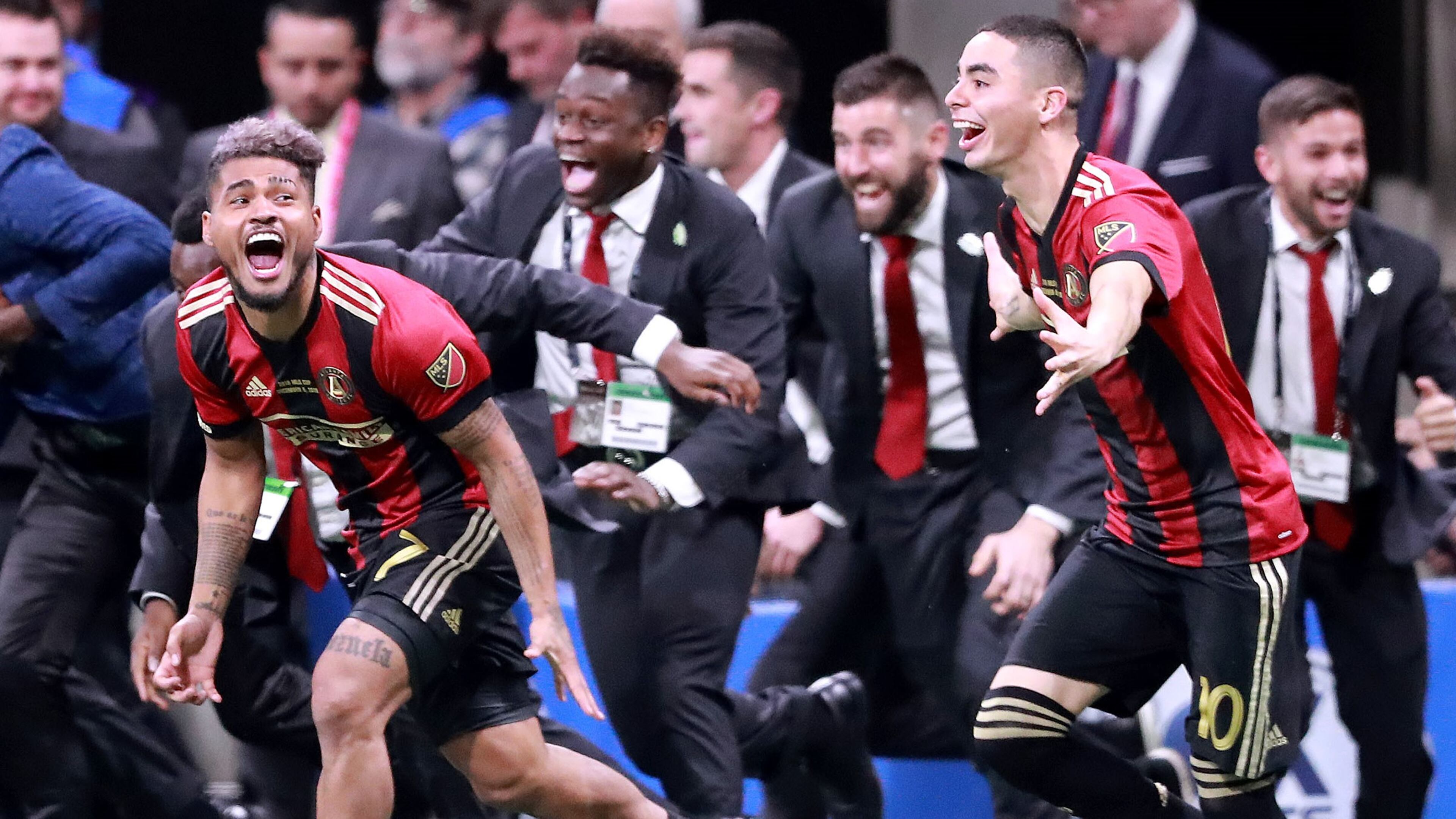 Atlanta United forward Josef Martinez (left) and midfielder Miguel Almiron charge the field to celebrate winning the MLS CUP on Saturday, Dec 8, 2018, in Atlanta. Curtis Compton/ccompton@ajc.com