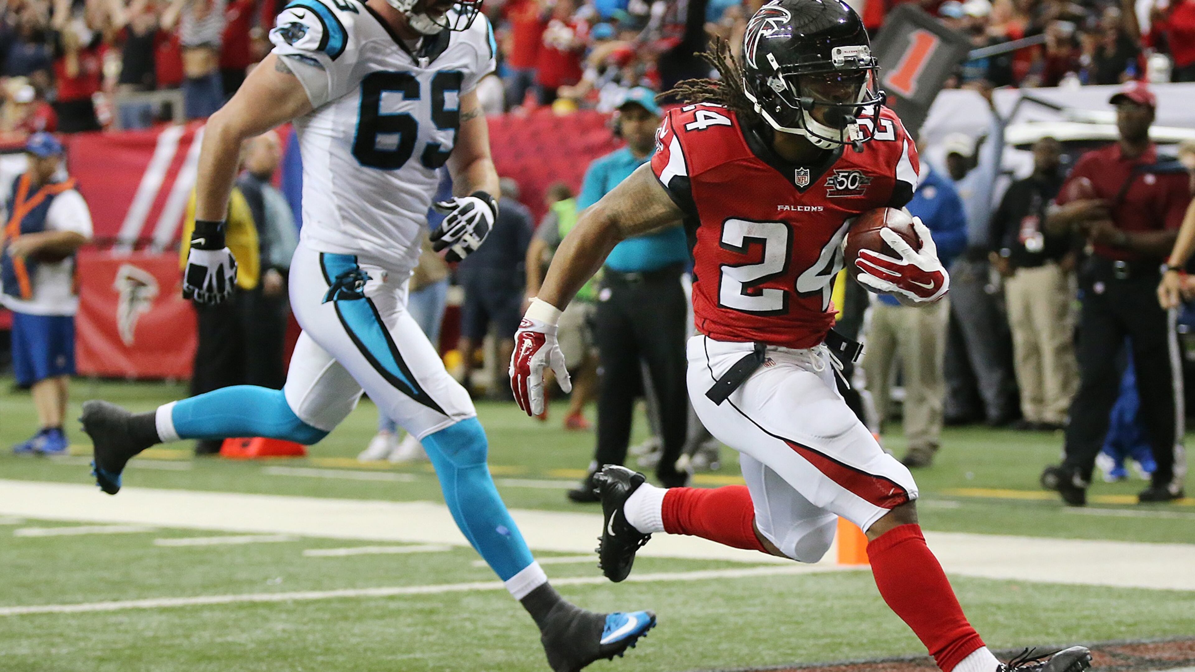 122815 ATLANTA: Falcons running back Devonta Freeman gets past Panthers Jared Allen for a touchdown to tie the game 7-7 during the second quarter in a football game on Sunday, Dec. 27, 2015, in Atlanta. Curtis Compton / ccompton@ajc.com