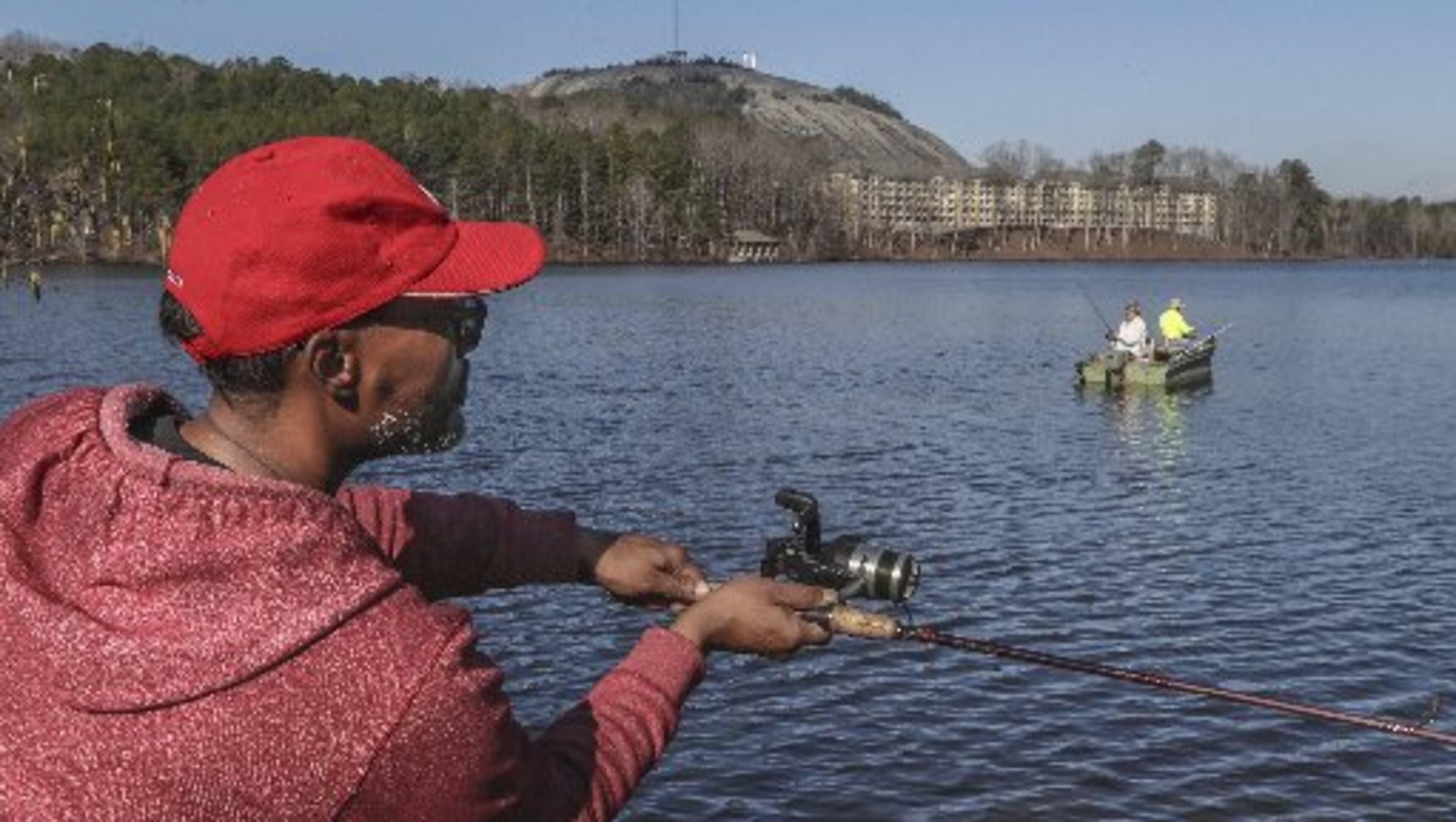 Derrick Monroe casts out onto Stone Mountain Lake on Thursday as temperatures continued to rise. JOHN SPINK / JSPINK@AJC.COM