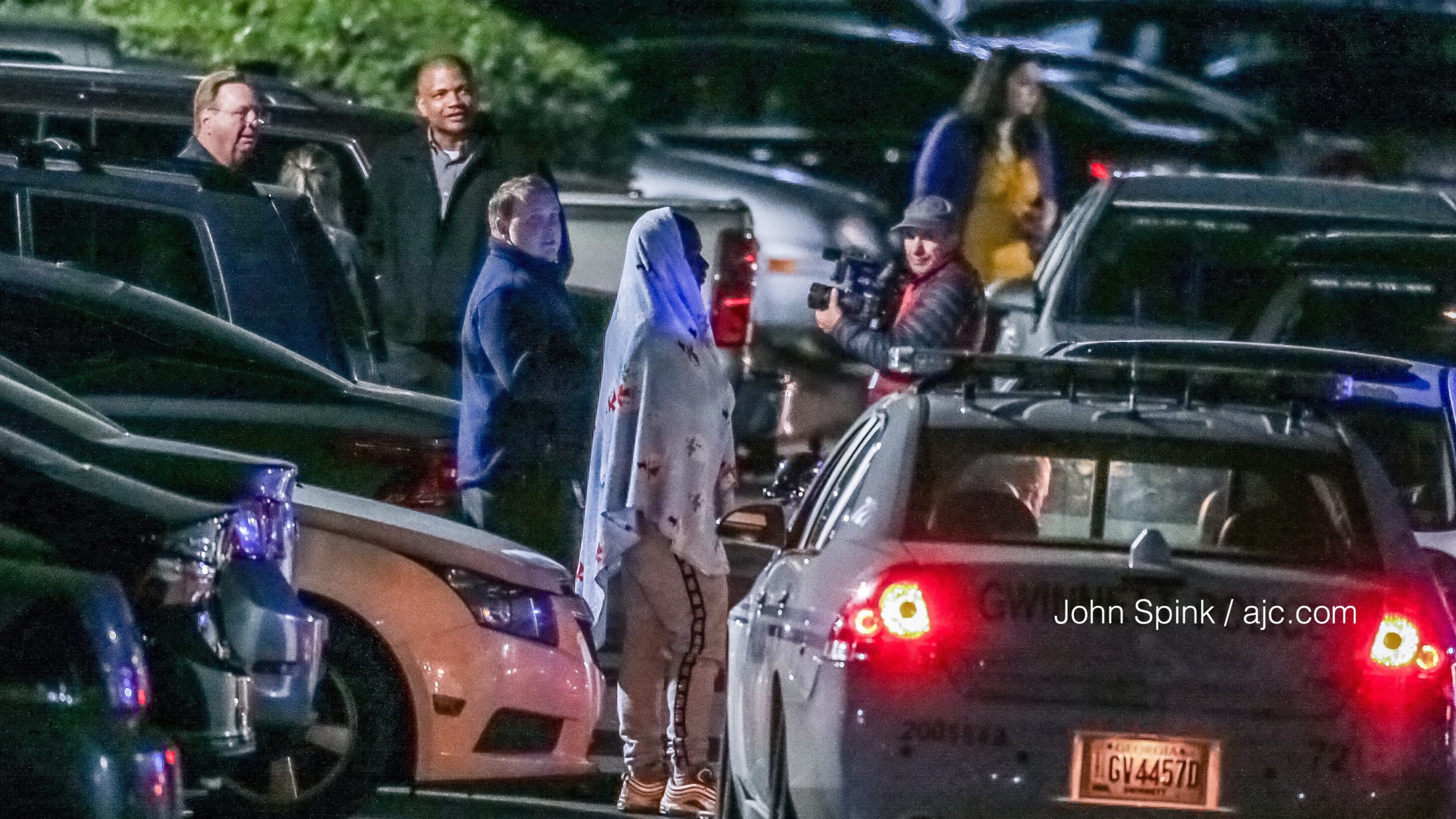 Residents wait in the parking lot of the Park at Peachtree Corners Apartments on Thursday morning while Gwinnett County police investigate a homicide. JOHN SPINK / JSPINK@AJC.COM