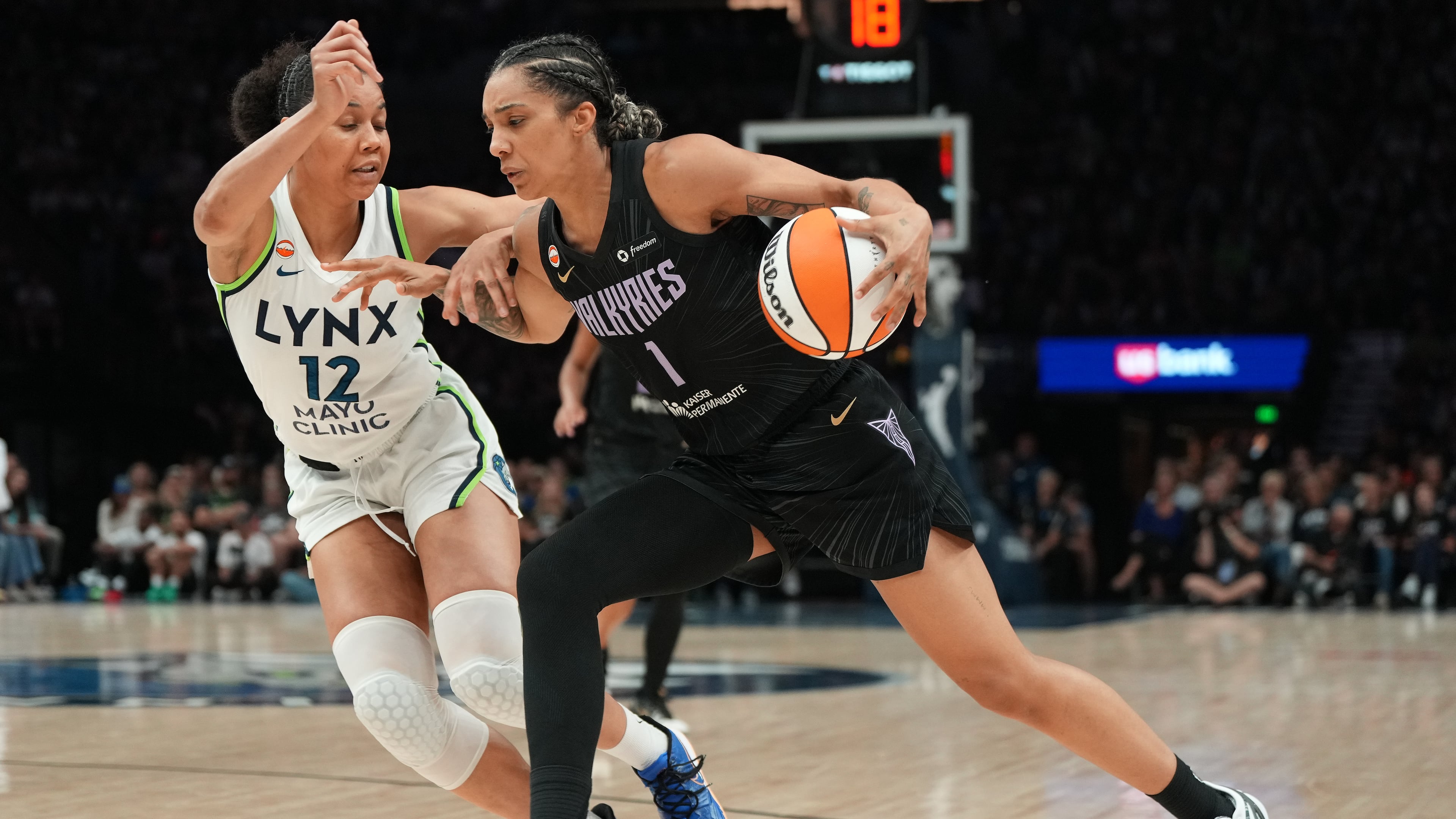 Golden State Valkyries forward Gabby Williams (1) works toward the basket as Minnesota Lynx forward Nia Coffey (12) defends during the second half of a WNBA basketball game Monday, Aug. 24, 2026, in Minneapolis. (AP Photo/Abbie Parr)