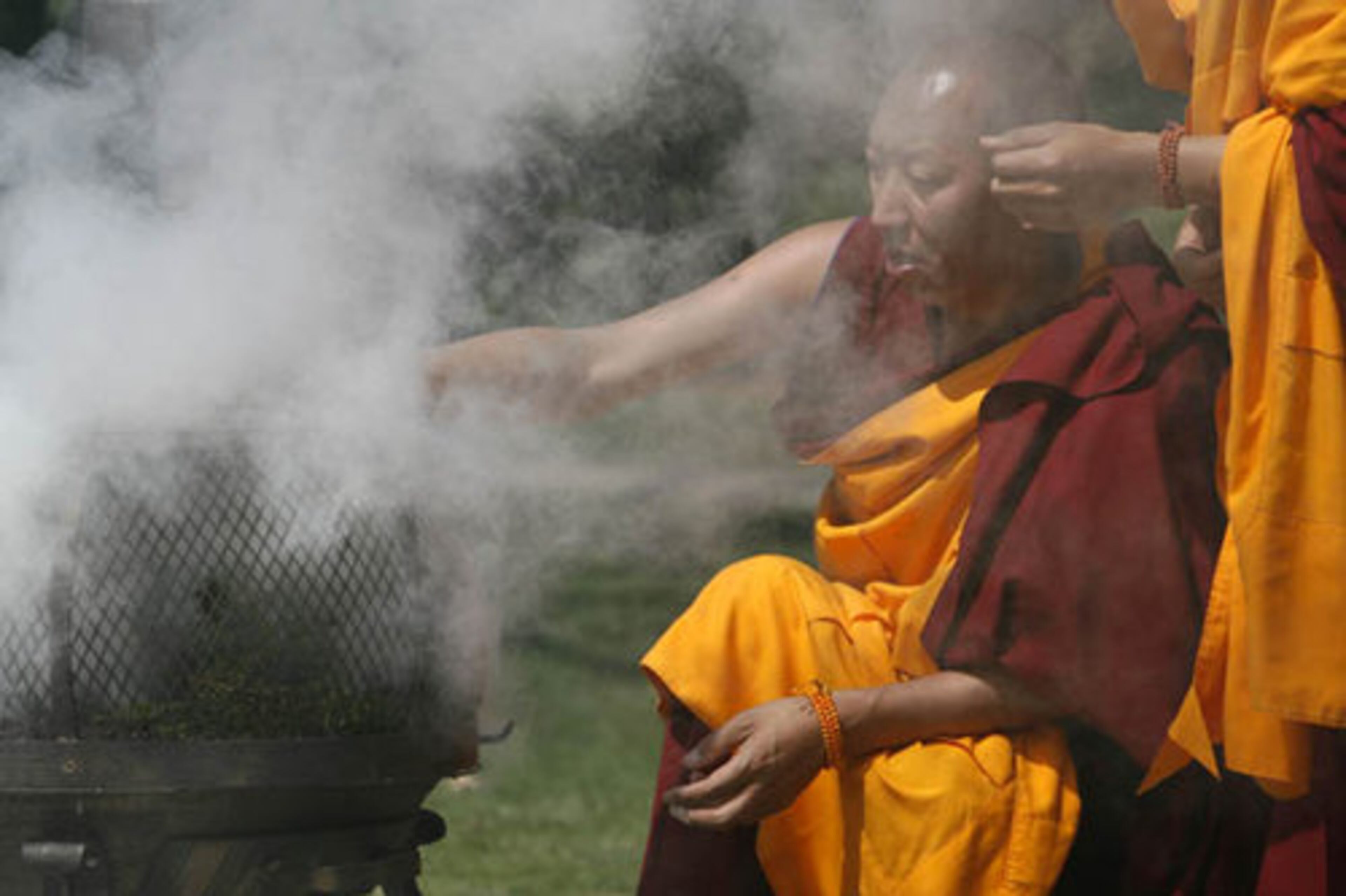 Tsering Phungtsok burns juniper shrubs as part of the ceremony to bring goodness, healing and peace.
