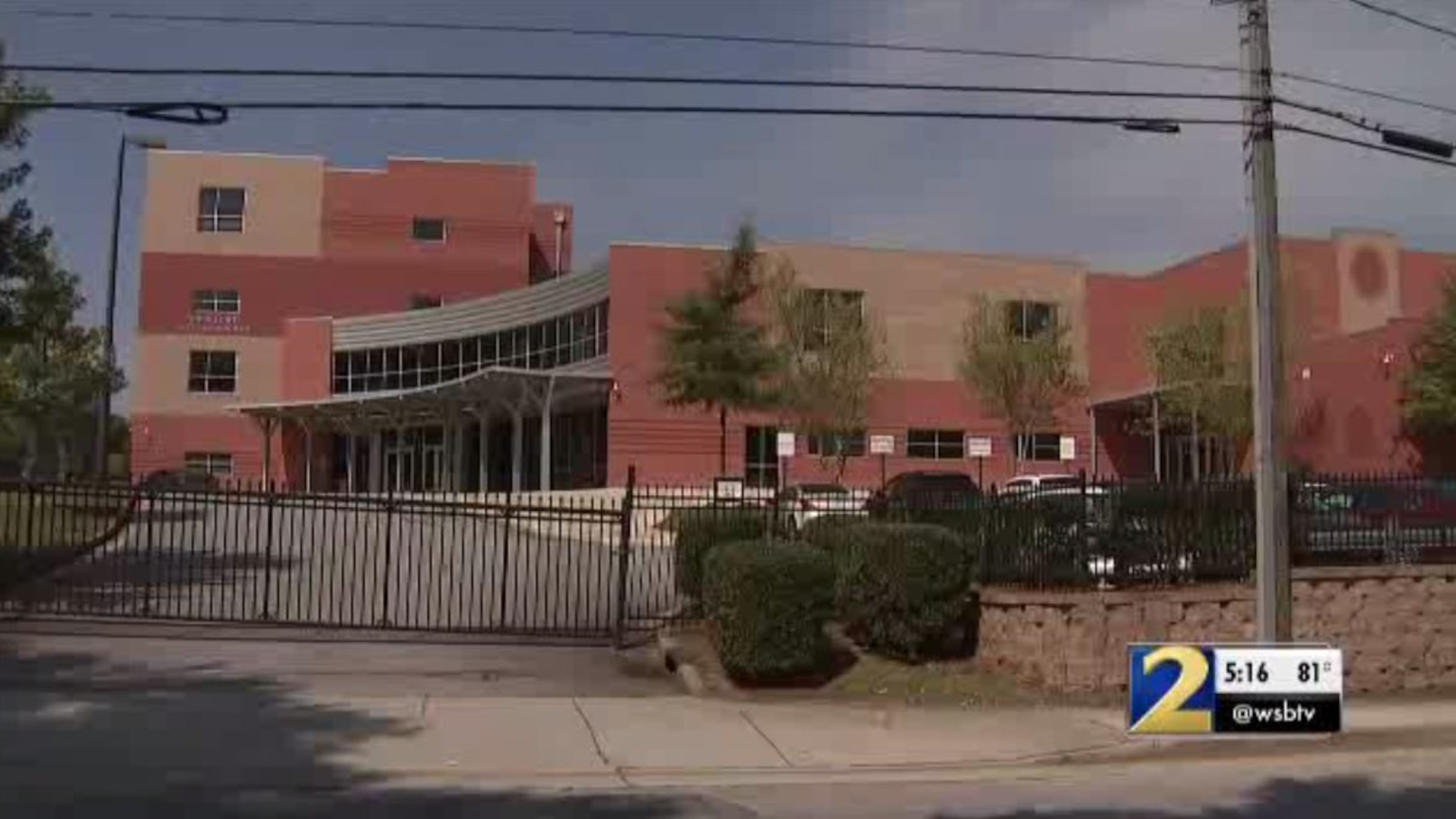 A teacher at John Lewis Invictus Academy has been placed on leave as the district investigates allegations that he slammed a 12-year-old student against a wall last week, authorities said.