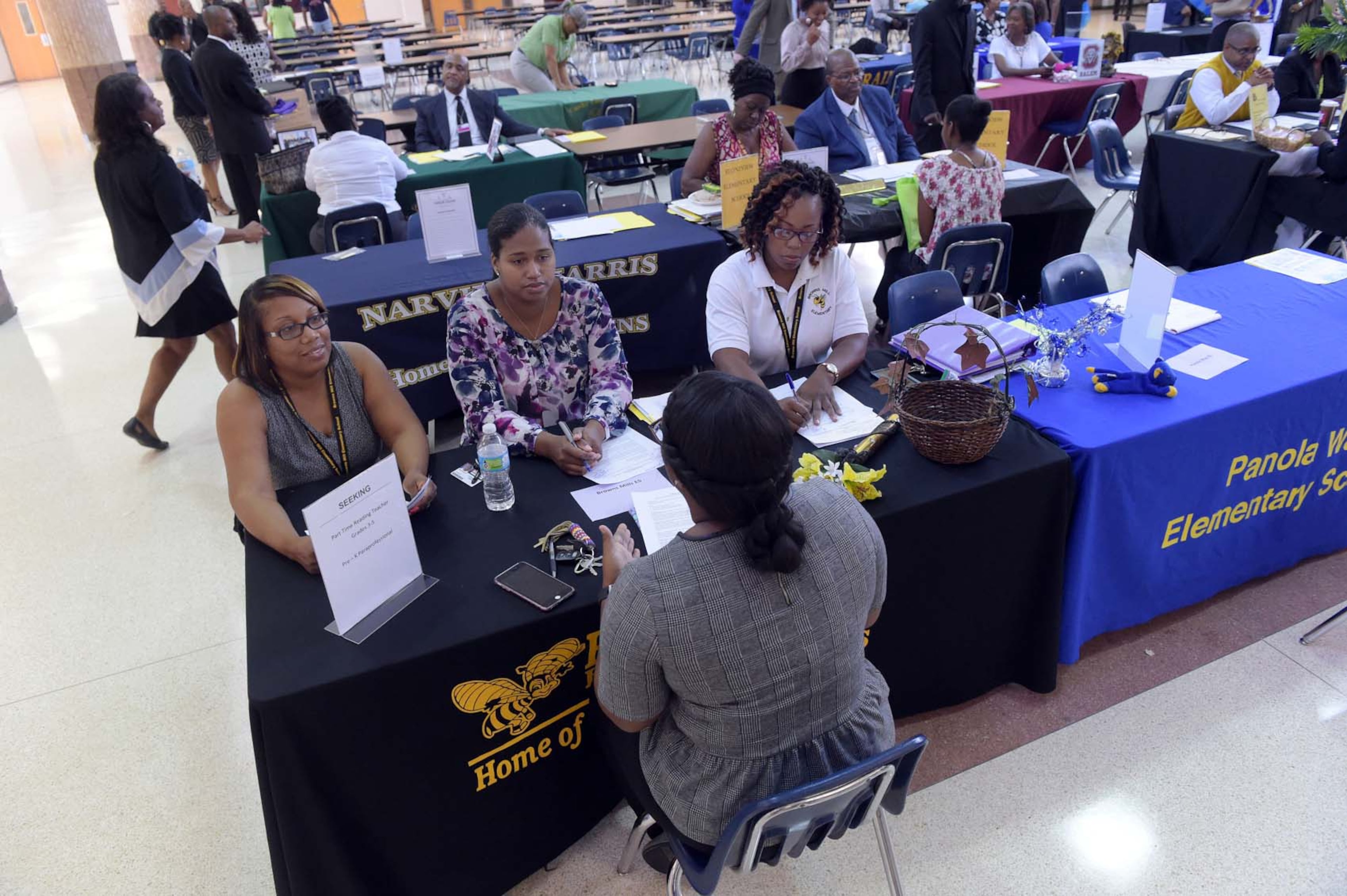 JULY 13, 2017 LITHONIA Browns Mill Elementary representatives Barbara Denton (from left), Stephanie Jones and Latonya Durden, talk with a candidate as teachers interview with several Region 4 schools during a job fair at DeKalb County's Martin Luther King Jr. High School in Lithonia, Thursday, July 13, 2017.
Metro Atlanta school districts are seeking more than 1,000 school teachers in the next few weeks to be fully staffed ahead of the 2017-2018 school year's start, just about a month away. Some districts say aggressive preplanning and better retention led to smaller deficits in 2017. Some critics have lashed out about uncertified teachers, which have helped with vacancies as many school districts opted into the Strategic Waiver School System, which allows for flexibility on qualifications for those at the front of classrooms. KENT D. JOHNSON / AJC