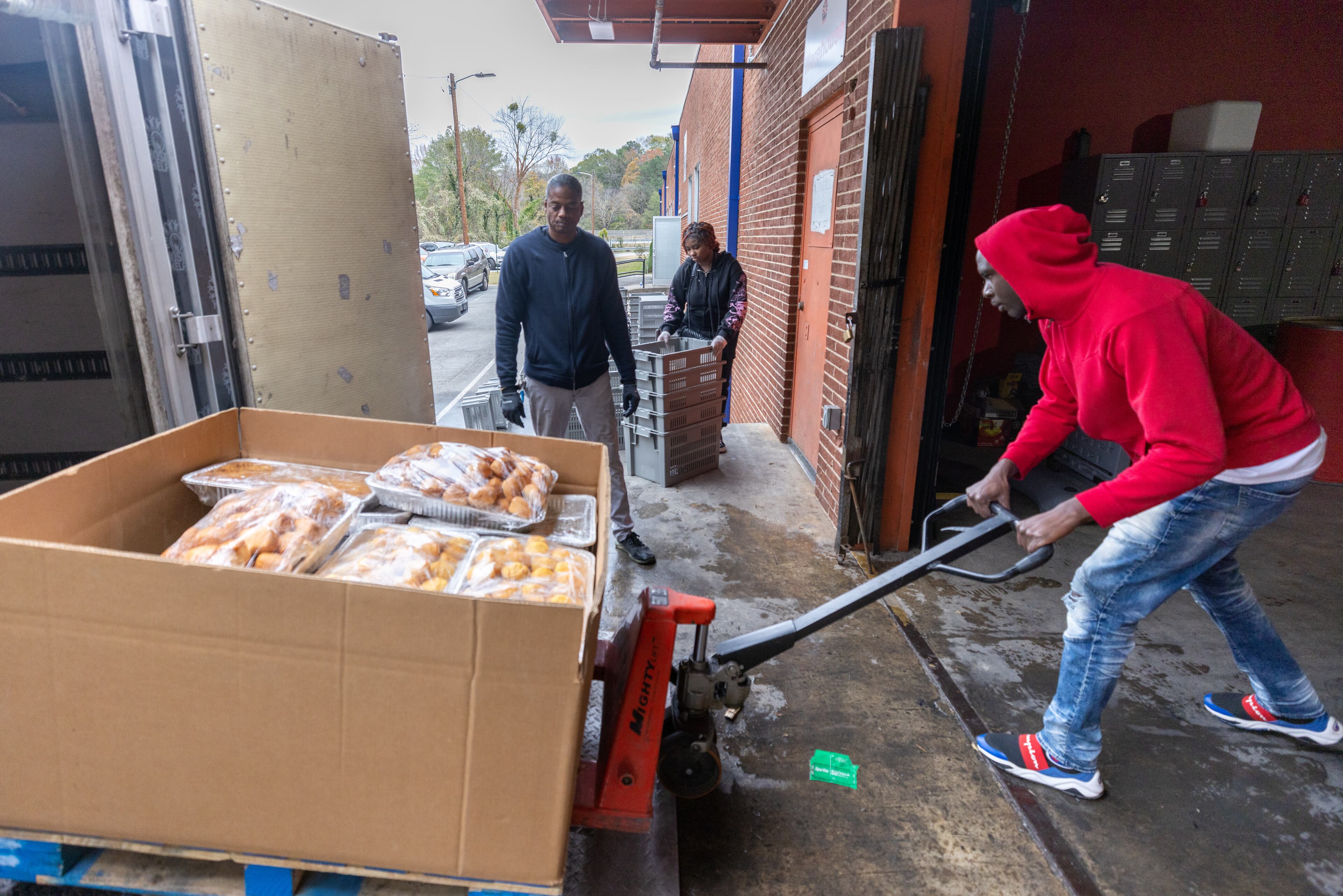 Hosea Helps truck driver Dexter Samples unloads prepared food, which will be used to make some of the 550 Thanksgiving meals at the headquarters in Atlanta on Thursday, November 24, 2022. (Steve Schaefer/steve.schaefer@ajc.com)