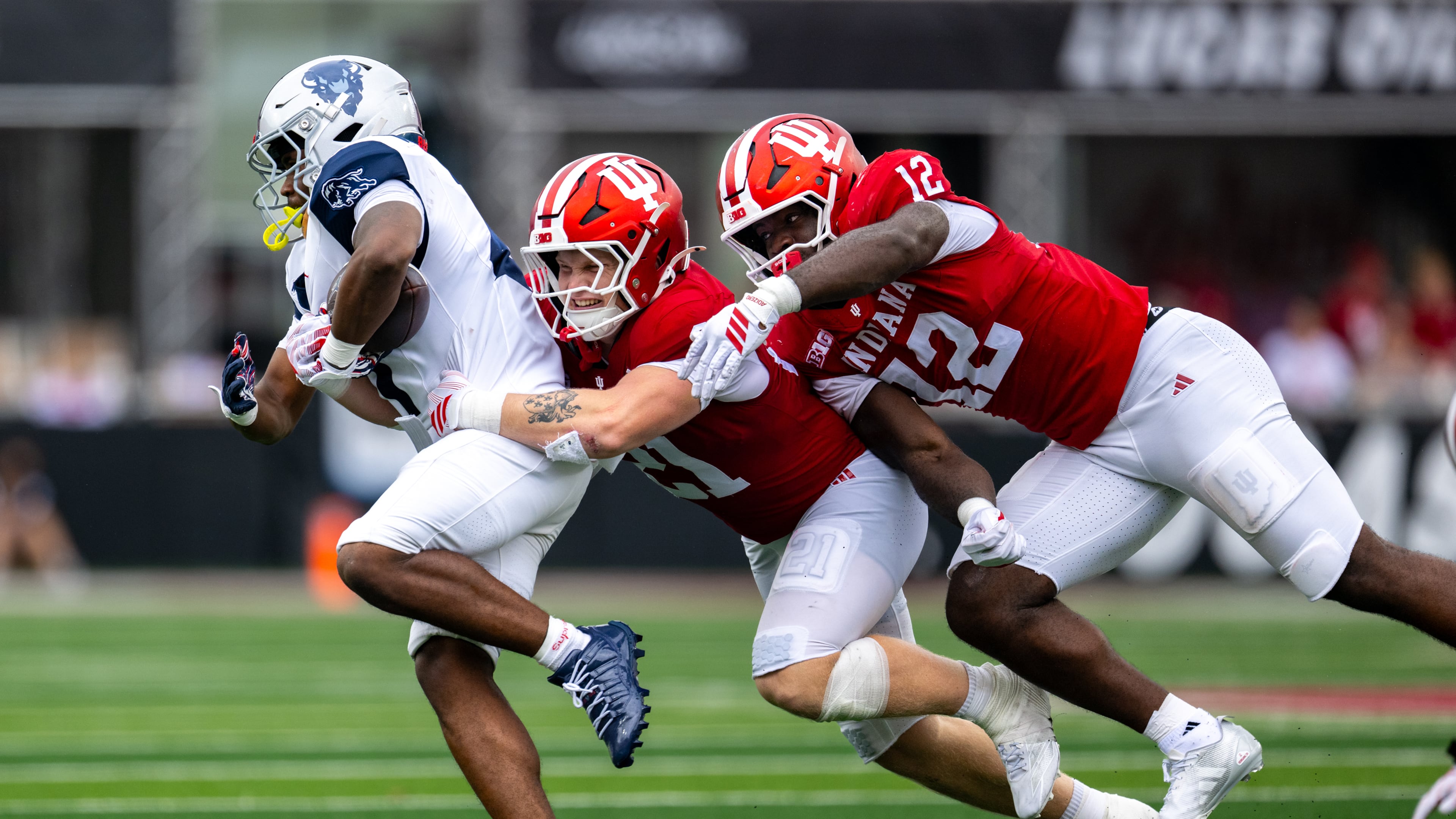 Howard running back John Washington IIl (left) is contacted by Indiana linebacker Jacob Savage (center) and defensive end Tobi Osunsanmi during the second half an NCAA college football game, Saturday, Sept. 12, 2026, in Bloomington, Ind. (Doug McSchooler/AP)