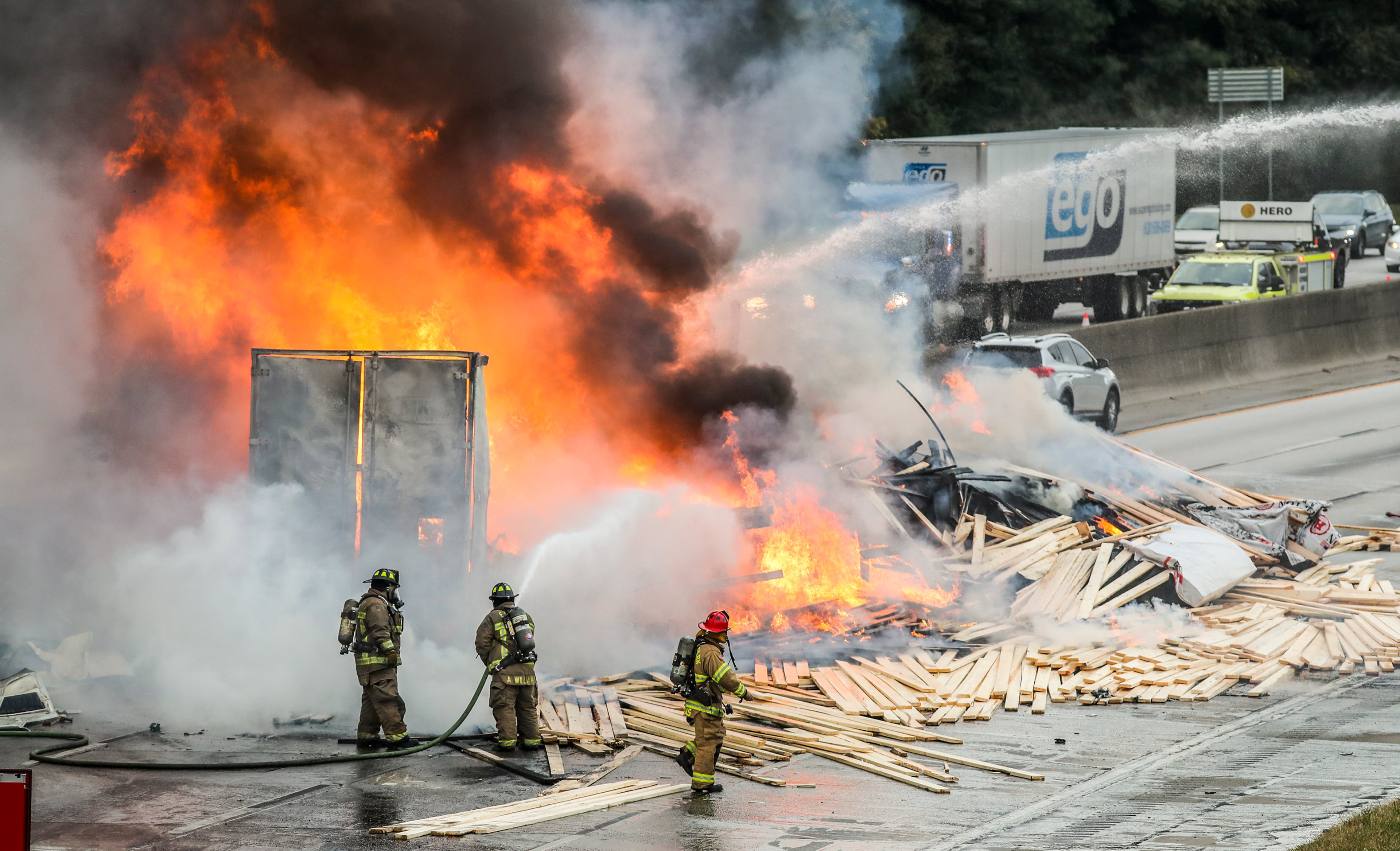 In the kind of calamity only possible in metro Atlanta traffic, two trucks carrying loads of lumber and candles collided on I-285 and burst into flames Thursday morning, Oct. 21, 2021. The matchstick made in heaven is also making a huge problem for fire crews in south Fulton County, who have shut down the entire I-285 Outer Loop to battle the blaze and clean up the wreck. (John Spink / John.Spink@ajc.com)