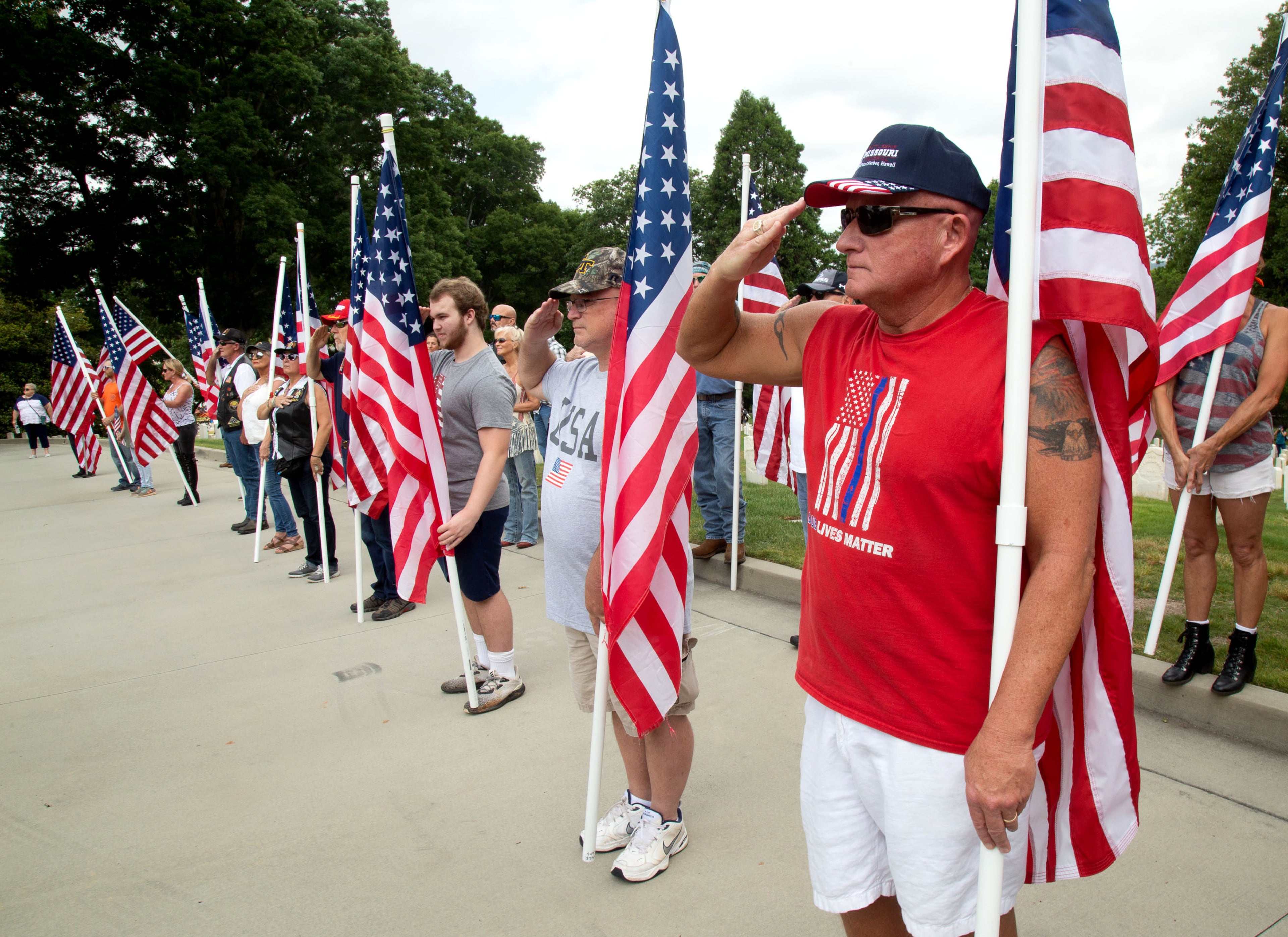 People salute during an unofficial wreath-laying ceremony at the Marietta National Cemetery Monday, May 25, 2020. STEVE SCHAEFER FOR THE ATLANTA JOURNAL-CONSTITUTION