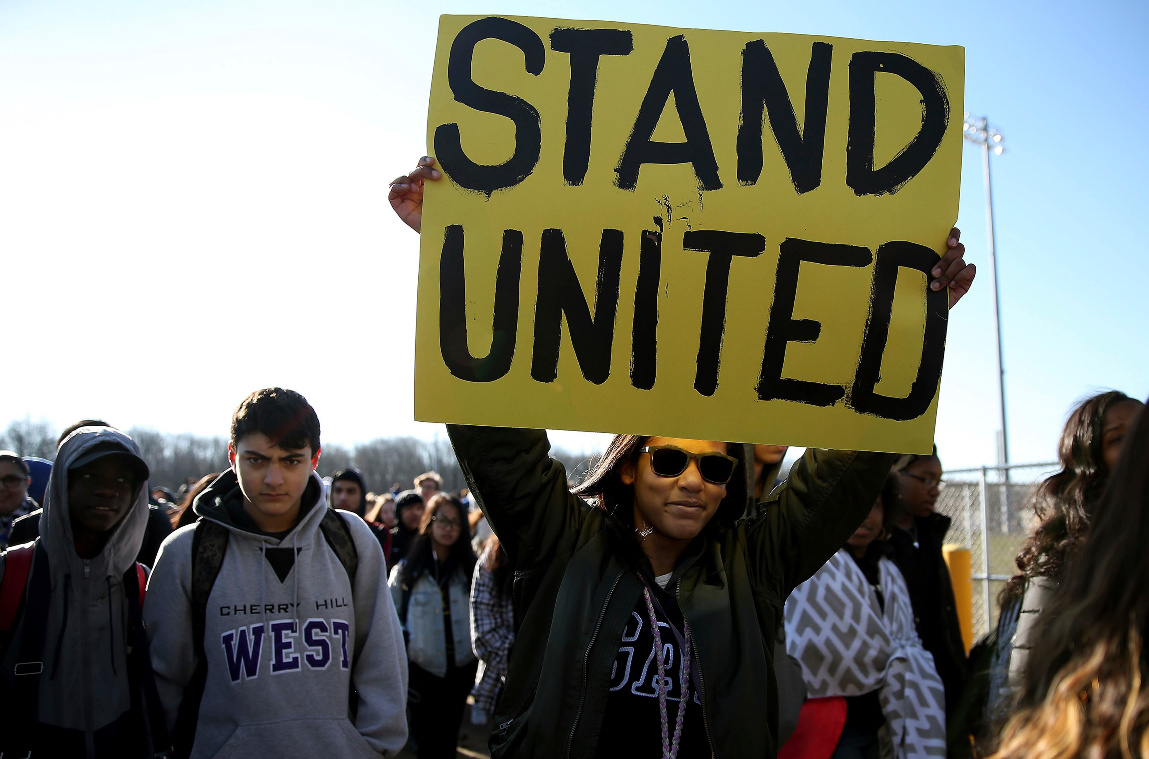 Freshman Kennedi Lawson, 14, carries a sign as student walkout at Cherry Hill West High School in remembrance of those killed in the Parkland, Fla., shooting in Cherry Hill, N.J., on Wednesday, March 14, 2018. ( David Maialetti /The Philadelphia Inquirer via AP)