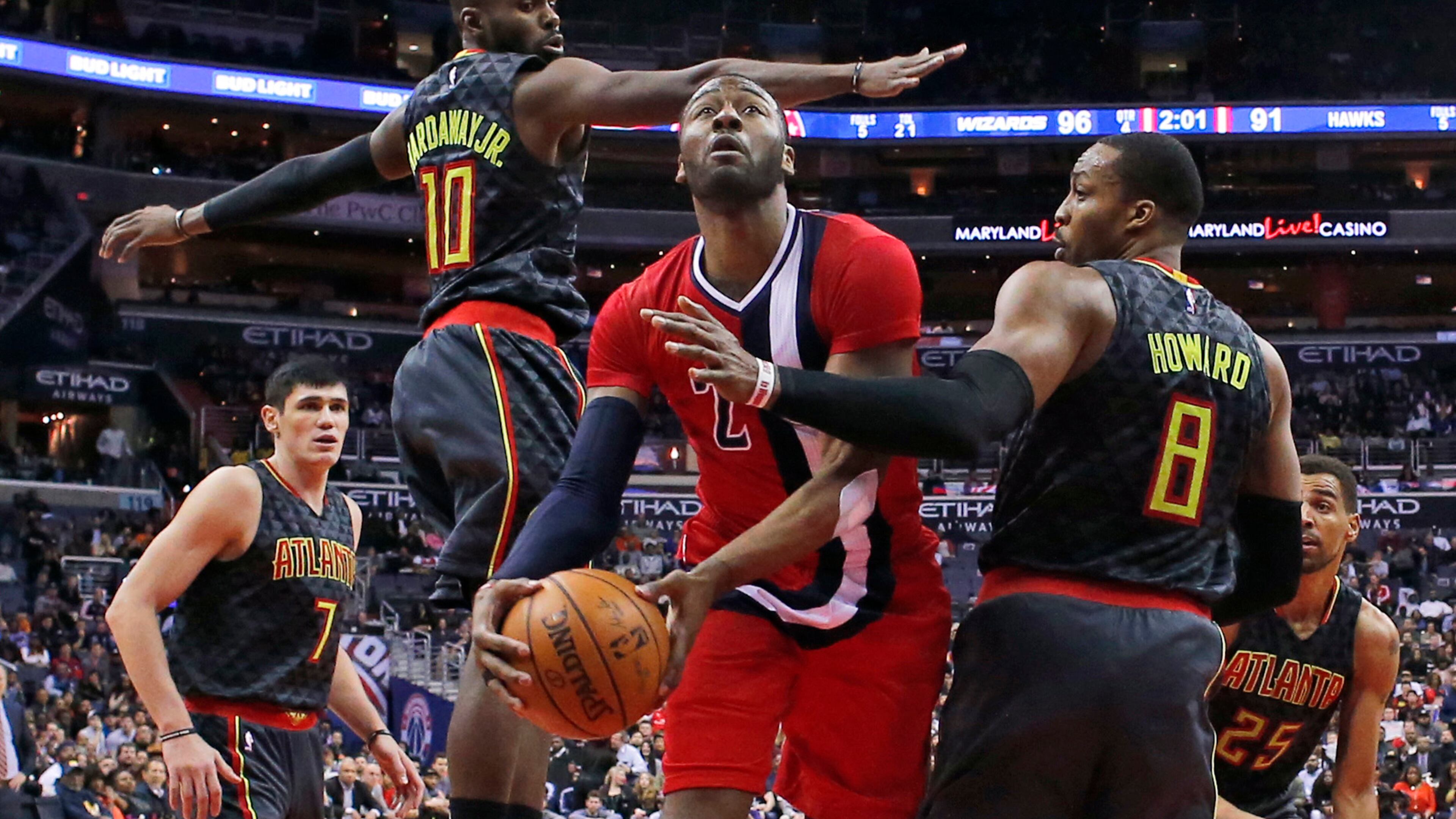 Washington Wizards guard John Wall (2) shoots between Atlanta Hawks forward Ersan Ilyasova (7), guard Tim Hardaway Jr. (10) and center Dwight Howard (8) during the second half of an NBA basketball game Wednesday, March 22, 2017, in Washington. The Wizards won 104-100. (AP Photo/Alex Brandon)
