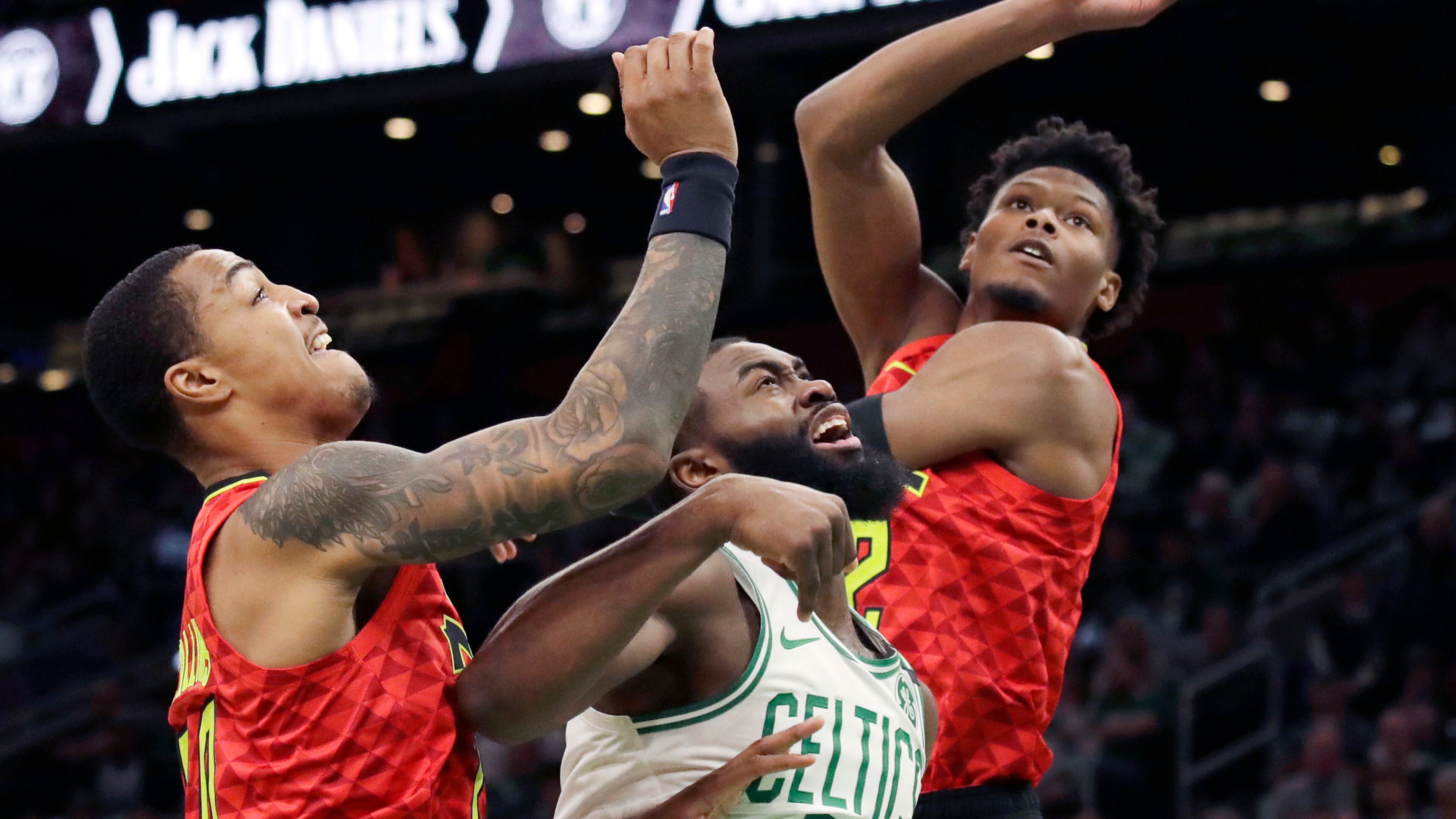 Boston Celtics guard Jaylen Brown (7) fights for rebound position against Hawks forwards John Collins, left, and Cam Reddish. (AP Photo/Elise Amendola)